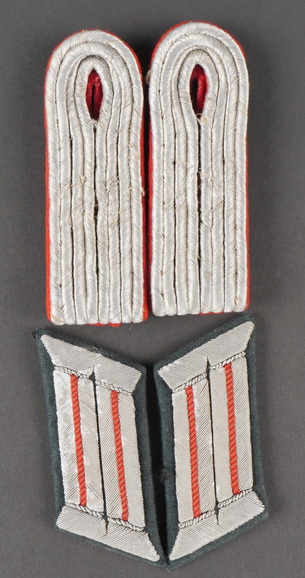 Insignes de lartillerie. German artillery insignia.: Insignes dofficier de lartillerie de la Heer. Comprenant une paire homogene de patte depaule de Leutnant , plateau et lisere realises en drap rouge. Quelques traces de mite visibles. Une paire homogen