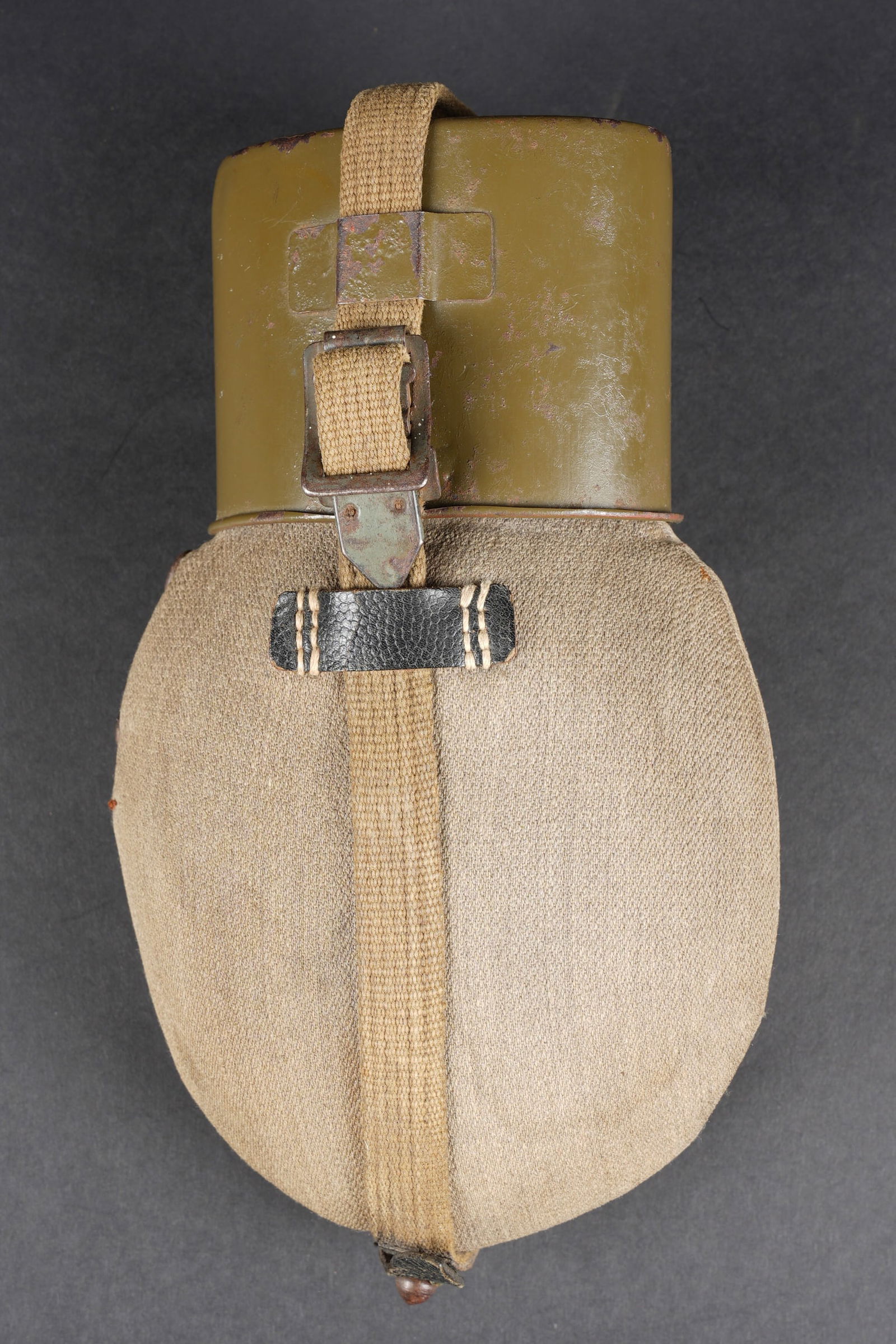 Gourde allemande. German canteen.: Gourde allemande. Gourde en metal emaille rouge. Bouchon en bakelite noire. Housse en toile ersatz grise. Les boutons pressions sont fonctionnels. Quelques taches visibles au niveau de la housse. Harn