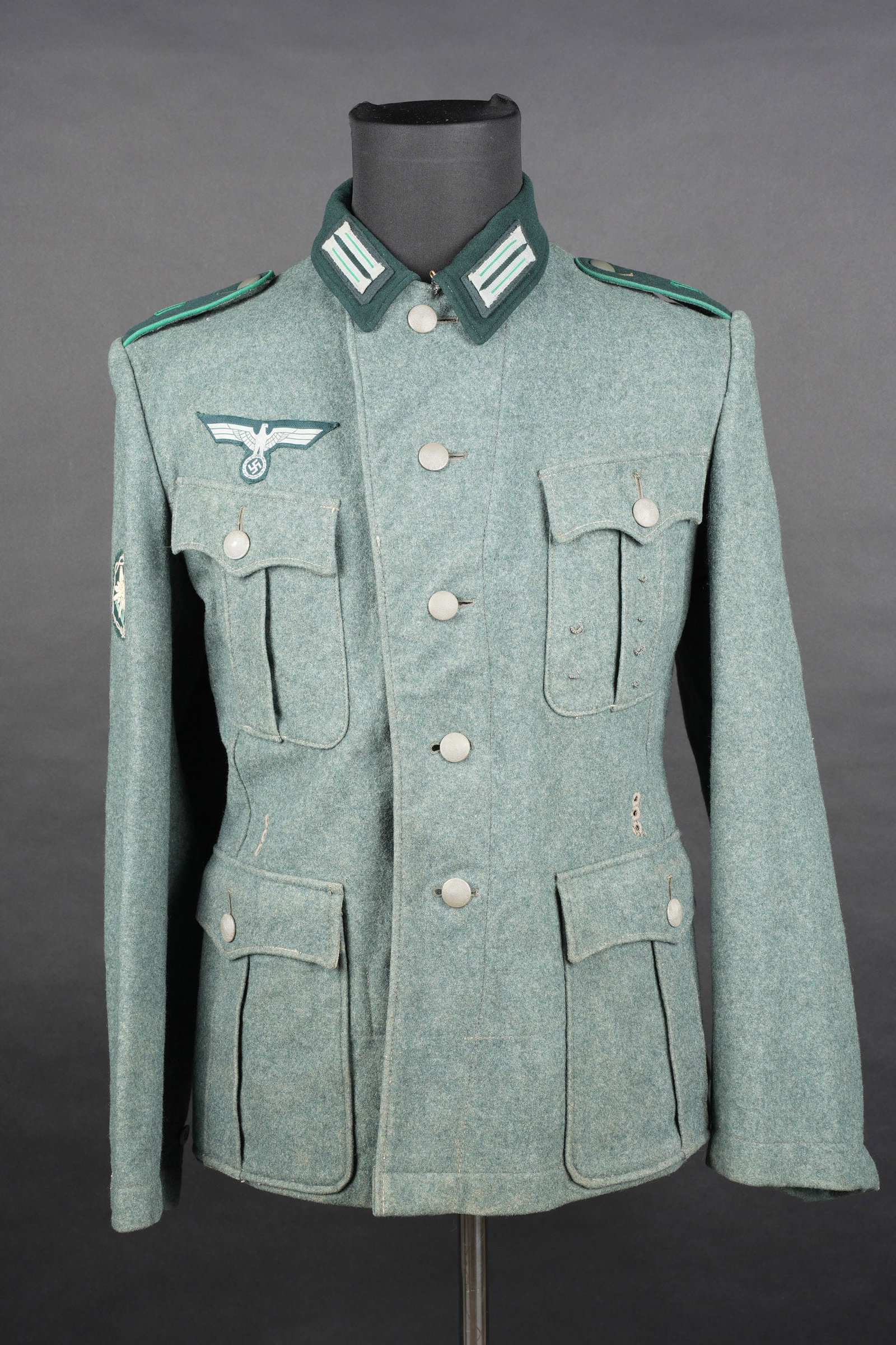 Vareuse Gebirgsjager. German mountain troops tunic.: Vareuse Gebirgsjager. Modele 35. En drap Feldgrau. Tous les boutons sont presents et majoritairement en couleur dorigine. Nombreuses brides de decorations au niveau de la poche de poitrine gauche. Aig
