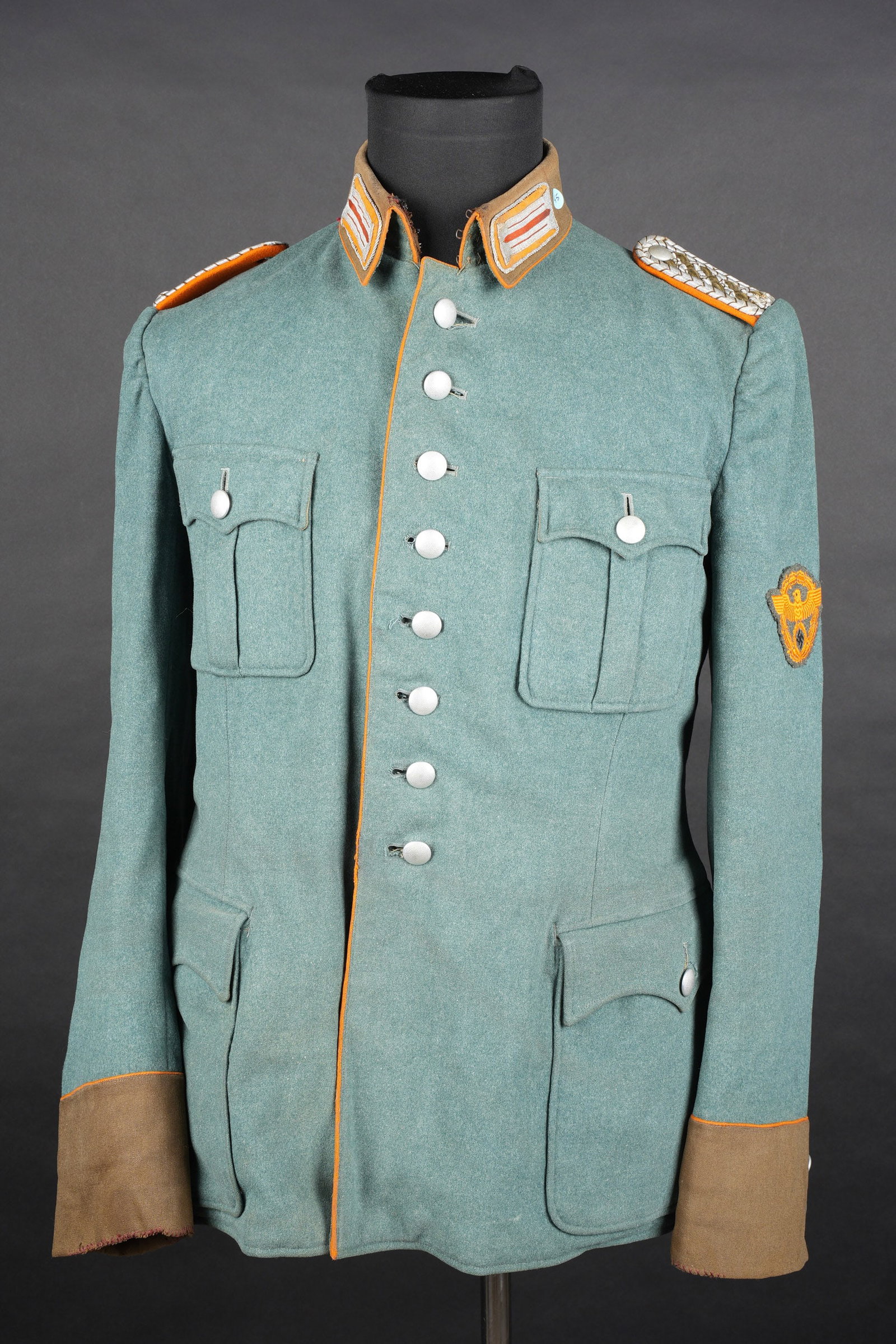 Vareuse Gendarmerie. German gendarmerie tunic.: Vareuse Gendarmerie. En drap grisvert. Tous les boutons sont presents. Lisere orange au niveau de la boutonniere, au bas des manche et autour du col. Pattes depaule de Meister. Aigle de manche brode c