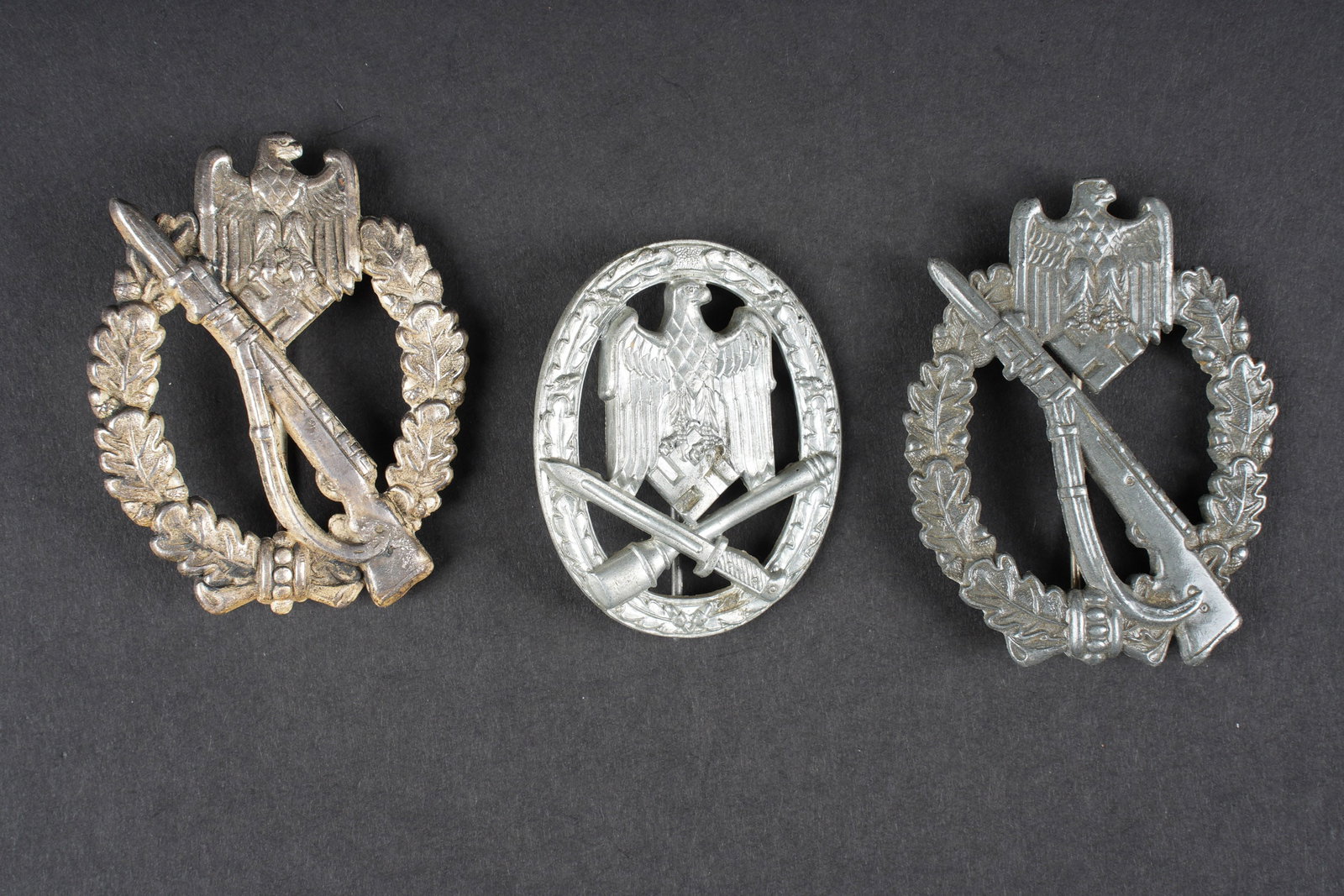 Decorations allemande. German insignia.: Decorations allemande. Comprenant un infanterie Sturmabzeichen, couleur argent a 70%, legerement tordu, fabrication creuse, attache complete, sans marquages visibles. Un insigne dassaut general, fabri