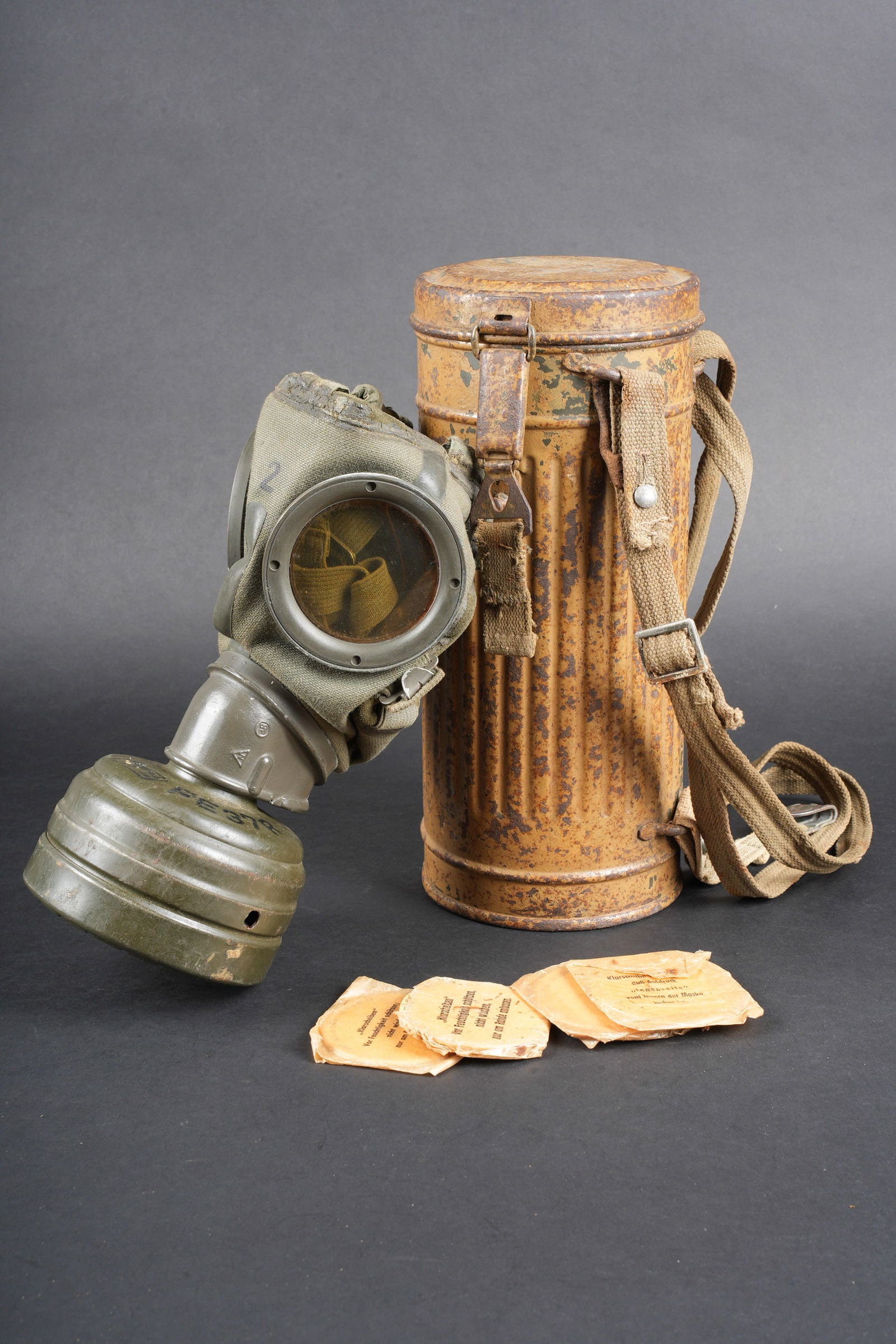 Masque anti-gaz camoufle. German camouflaged gas mask.: Masque anti-gaz camoufle. Boitier long en metal. Peinture camoufle verte claire voir sable a 70%. Toutes les sangles sont presentes, mais de modeles differents. Quelques taches de peinture bleue visib