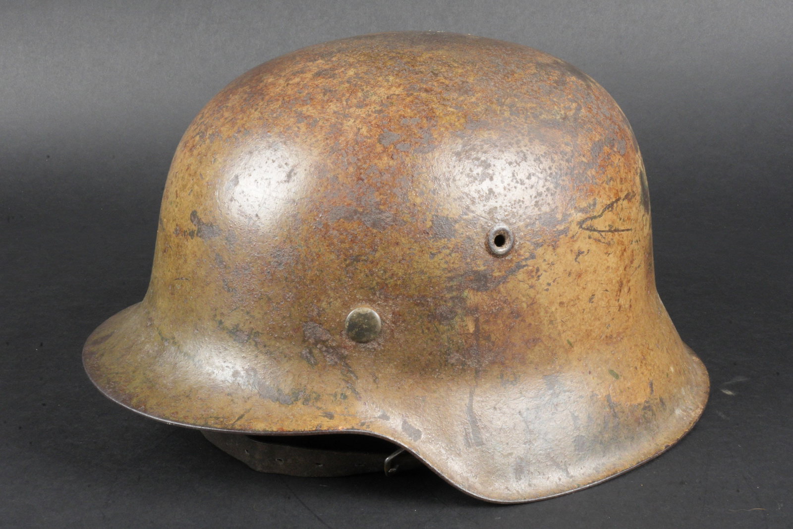 Casque camoufle Heer. German camouflaged helmet.: Casque camoufle de la Heer. Coque de casque M42. Fabrication ET 60. Numero de lot 2421. Cerclage en metal complet. Coiffe absente. Jugulaire en cuir presente, mais incomplete. Peinture exterieure camo