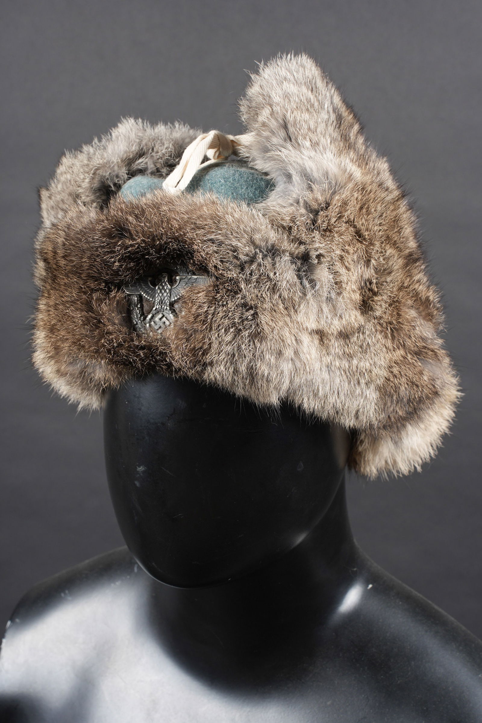 Bonnet Polizei. German police cap.: Bonnet hivernal Polizei. En drap grisvert. Doublure en fausse peau de lapin. Le cordon de maintien des rabats est present. Insigne Polizei metallique. Linsigne de la police na pas ete demonte afin de