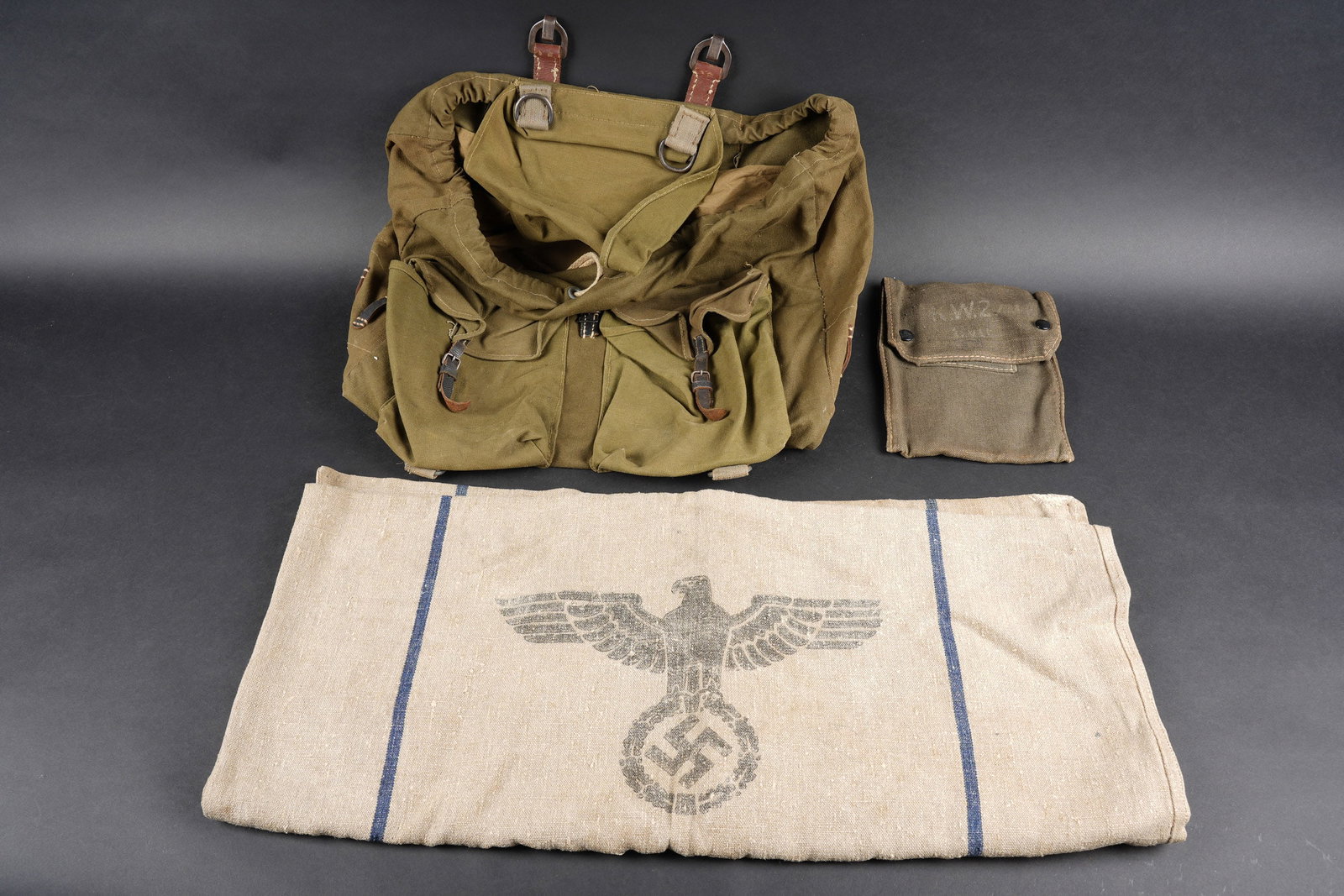 Equipements allemand. German equipment.: Equipements allemand. Comprenant un sac a dos en forte toile Feldgrau et cuir noir. Les bretelles sont manquantes. Le cordon de serrage est present. Date 1944. Un sac a vivre en forte toile ecrue, bel