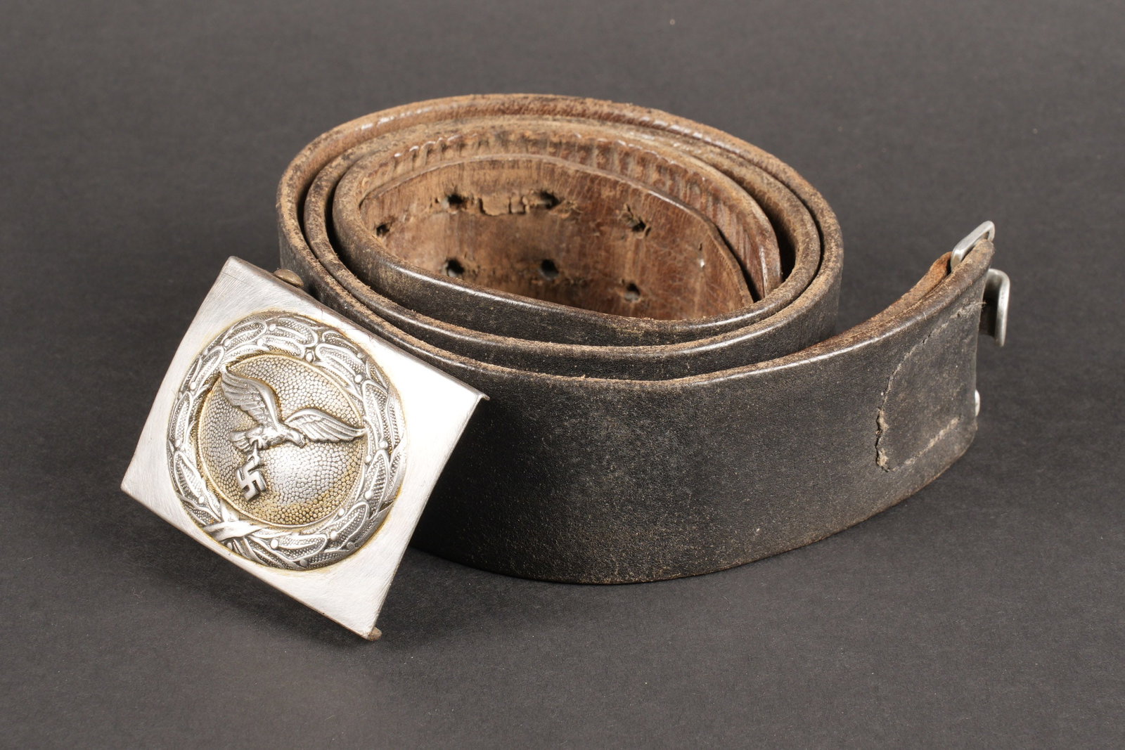 Ceinturon LW. Luftwaffe belt.: Ceinturon de la Luftwaffe. Ceinturon en cuir noir, bouclerie en metal. Les marquages sont illisibles, taille 92. Patte de reglage complete. Boucle de ceinturon de la Luftwaffe, fortement nettoyee, log