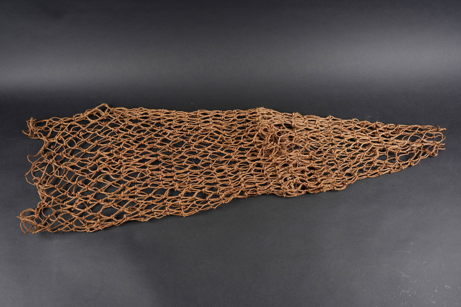 Filet de camouflage. German camouflage net: Filet de camouflage. Realisation sous forme de nasse. Les cordelettes sont tressees. A noter une certaine usure et patine de la piece. Etat II+. Camouflage net. Constructed in net form with braided co