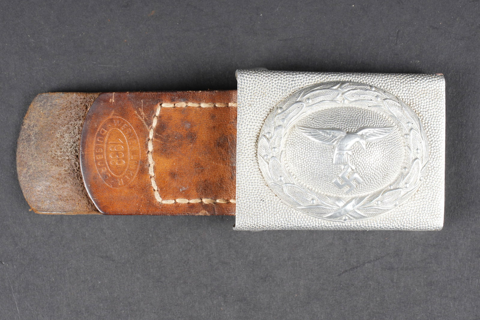 Boucle de ceinturon LW. Luftwaffe belt buckle.: Boucle de ceinturon de la Luftwaffe. En aluminium grenele. Aigle de la Luftwaffe du premier type. Fabrication en deux parties. Patte en cuir marron, complete, datee 1939. A noter une legere usure et p