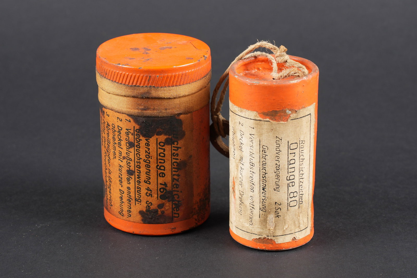 Fumigenes de survie LW. Luftwaffe survival smoke signal flares.: Fumigenes de survie de la Luftwaffe. Vides. Comprenant un boite en metal, de couleur orange, le couvercle est present, ainsi que sa petite cordelette. Etiquette marquee Rauchsichtzeichen Orange 80. Fa