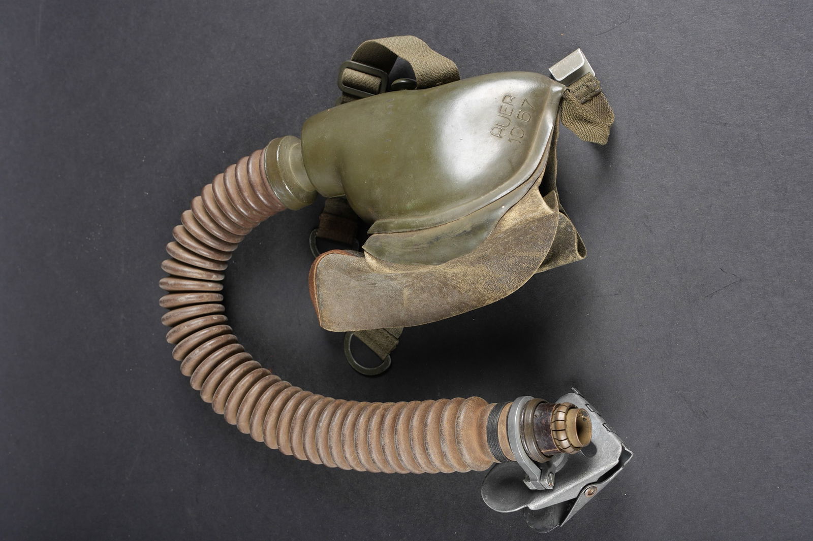 Masque a oxygene LW. Luftwaffe pilot’s oxygen mask: Masque a oxygene Luftwaffe. Masque en caoutchouc Feldgrau, les bavettes laterales sont presentes et doublees de peau de chamois. Fabrication Auer 1067. Taille 2. Toutes les sangles de fixation au serr