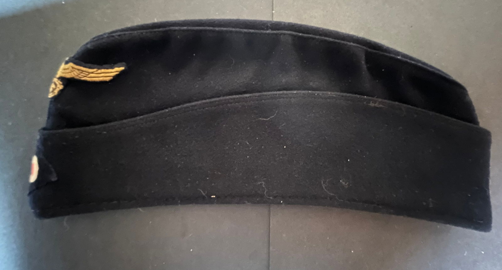 Calot Kriegsmarine. Kriegsmarine side cap.: Calot de marin de la marine de guerre Kriegsmarine en drap avec doublure en toile noire complet avec ses insignes et une etiquette nominative imprimee partiellement decousue taille environ 56. Kriegsm