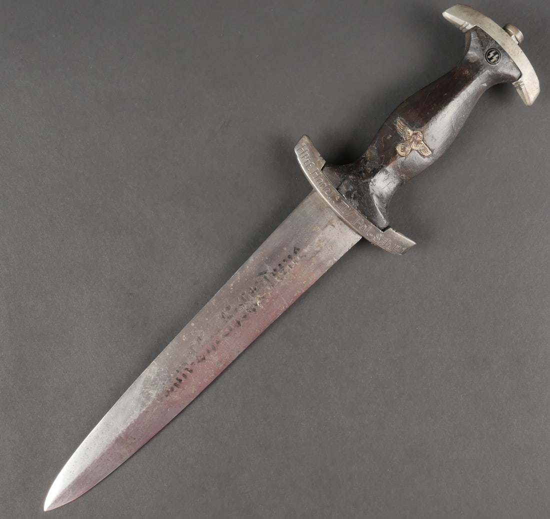 Dague SS personnalisee. Personnalized SS dagger.: Dague SS personnalisee. Garnitures metalliques presentant une certaine usure. Vis de pommeau portant les initiales HR. Manche en bois noir, fortement use avec des manques et fissures. Insigne SS et ai