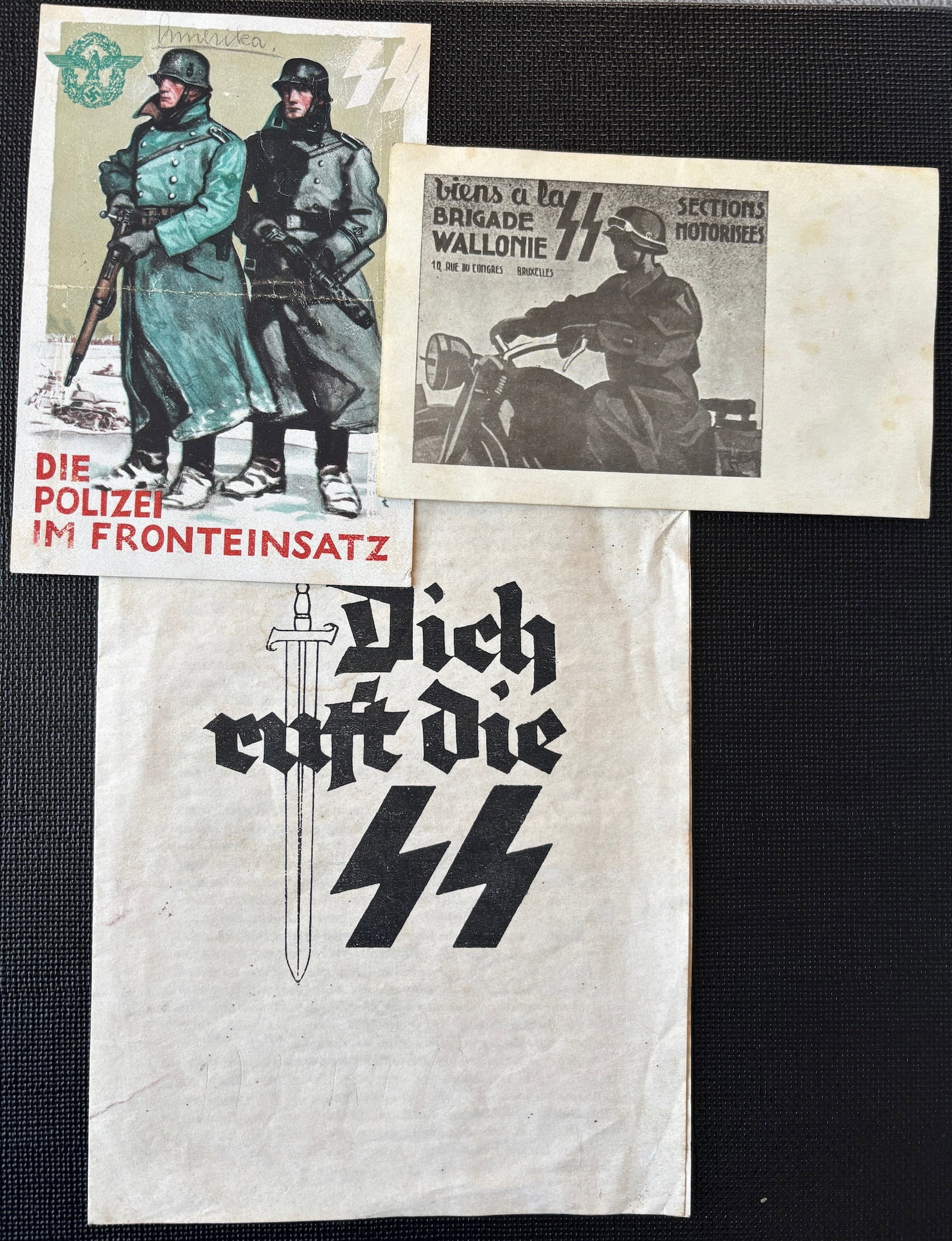 Cartes postales SS. SS postalcards.: Cartes postales SS. Comprenant une carte postale en coleur, marquee Die Polizei im Fronteinsatz, traces de colle au dos. Deux cartes postales SS Wallonie. Traces de colle au dos. On y joint un fascicu