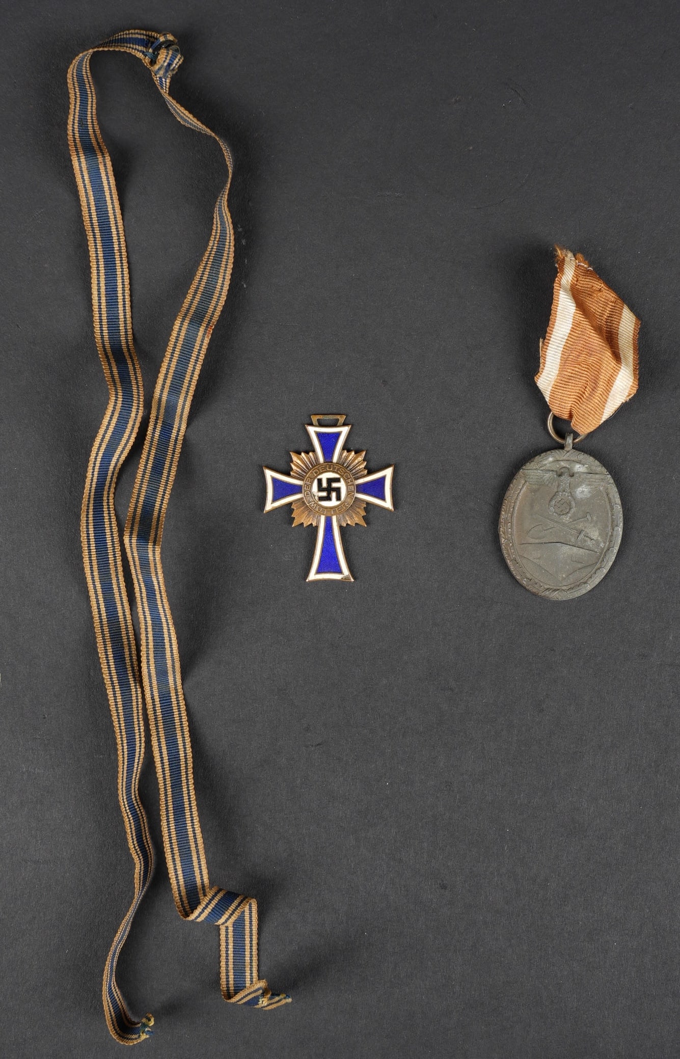Mutterkreuz. Mother's Cross Medal.: Mutterkreuz. Modele bronze, en metal emaille. Ruban complet, datee 1938. On y joint une medaille du Mur de l Atlantique avec ruban. A noter une certaine usure et patine des pieces. Etat II+. Mother’