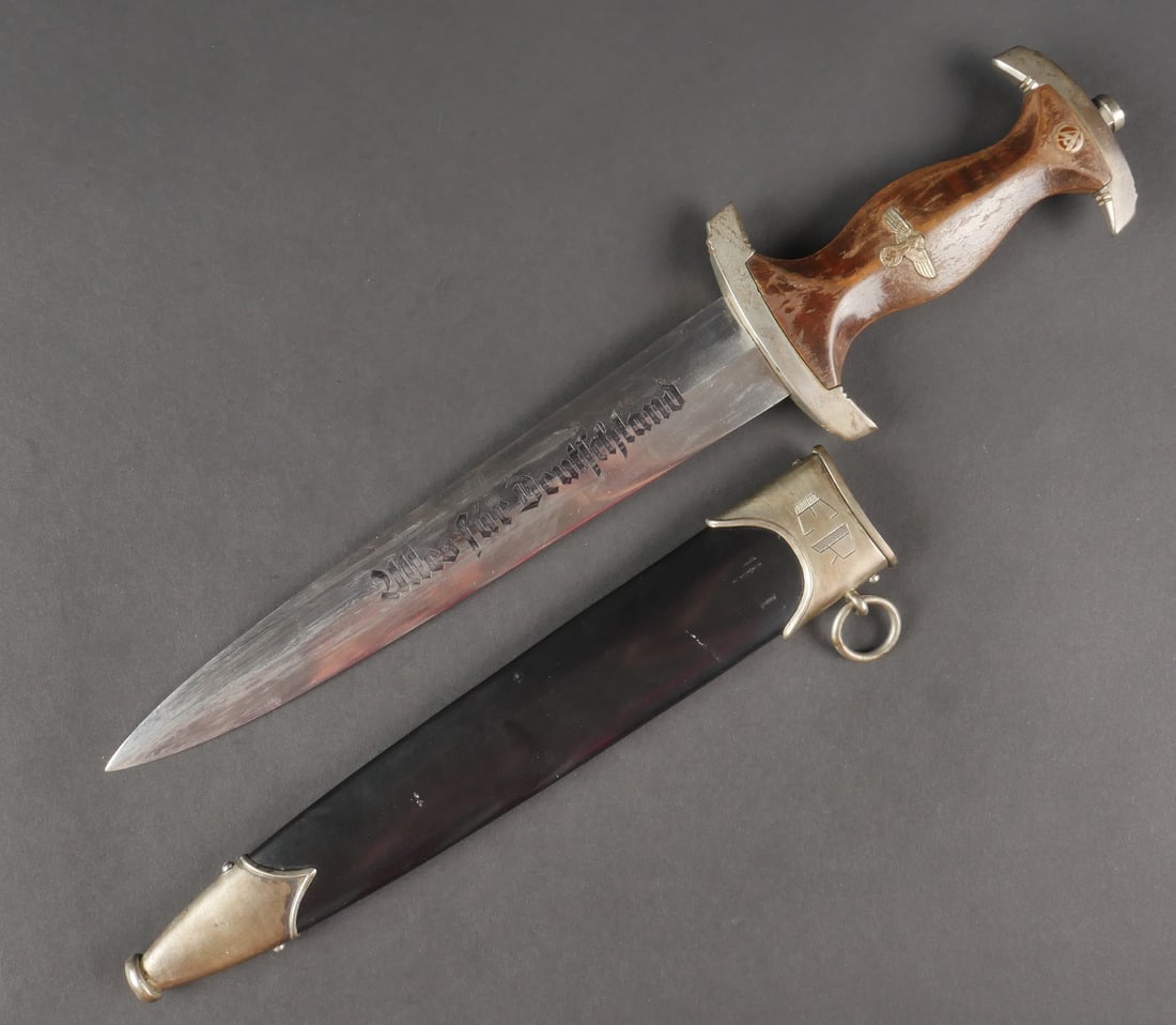 Dague NSKK personnalisee. NSKK personnalized dagger.: Dague NSKK personnalisee. Garniture en metal couleur argent. Poignee en bois, le vernis est quasiment absent. Fortement nettoyee. Aigle allemand et insigne SA bien fixes sur la poignee. Garde portant