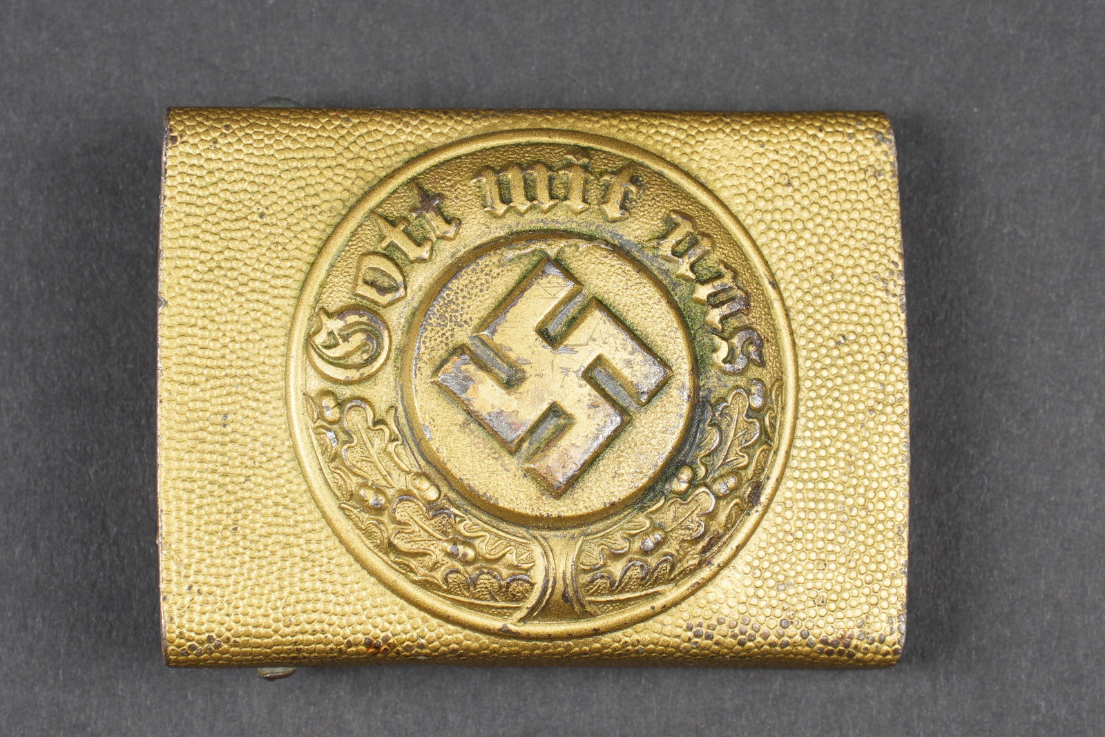 Boucle de ceinturon Wasserschutzpolizei. Wasserschutzpolizei belt buckle: Boucle de ceinturon de la Wasserschutzpolizei. En aluminium grenelee, couleur or. La dorure est fortement abimee avec des traces de nettoyage. Un ardillon casse. A noter une certaine usure et patine d