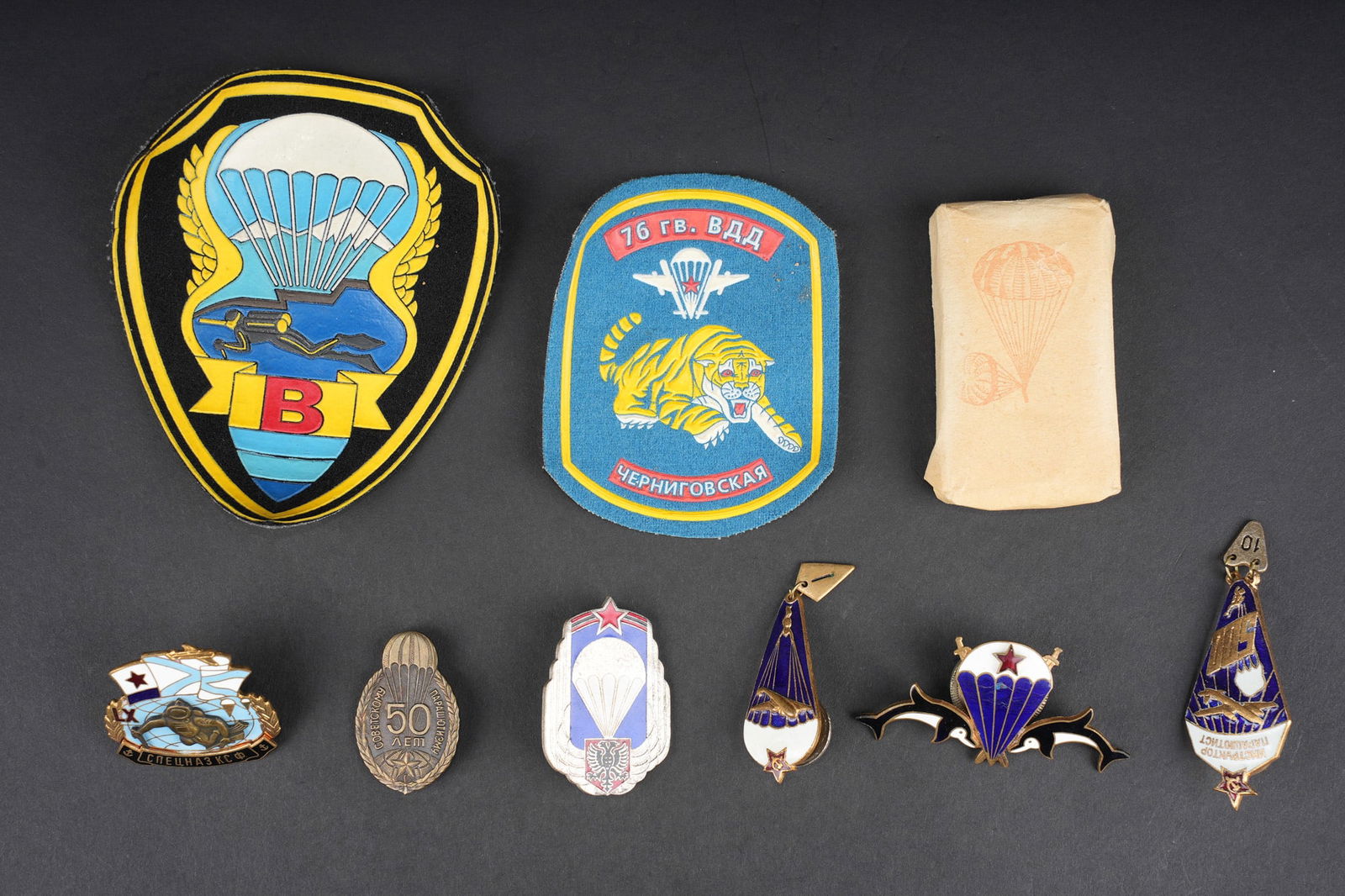 Insignes parachutiste russe. Russian paratrooper insignia.: Russie sovietique lot d insignes parachutistes. 6 insignes metalliques et 2 en tissu, relatifs aux parachutistes sovietiques dont plongeurs. On y joint un paquet de tabac. Usure d usage. Soviet