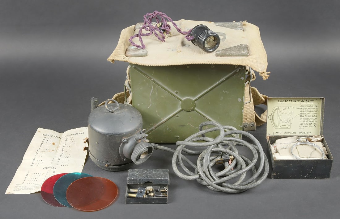 Lampe de signalisation britannique. British Signal Lamp.: Lampe de signalisation britannique. Belle caisse en metal. Peinture kaki a 70%. Le couvercle est recouvert d un epais tissu web. La sangle de transport est presente. Lampe complete, ainsi que de nombr