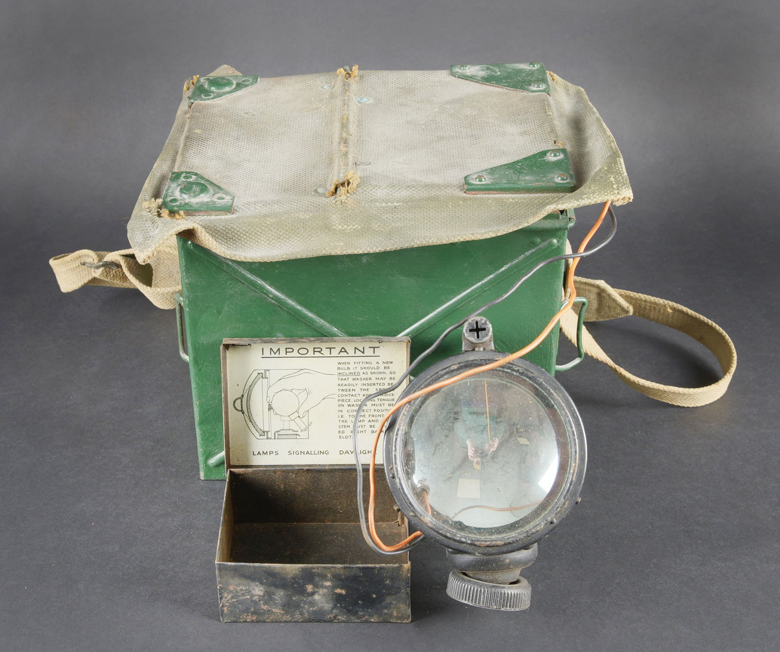 Lampe de signalisation britannique. British Signal Lamp.: Lampe de signalisation britannique. Belle caisse en metal. Peinture vert fonce posterieur. Couvercle recouvert d une toile web blancotee. La sangle de transport est presente. Lampe de signalisation