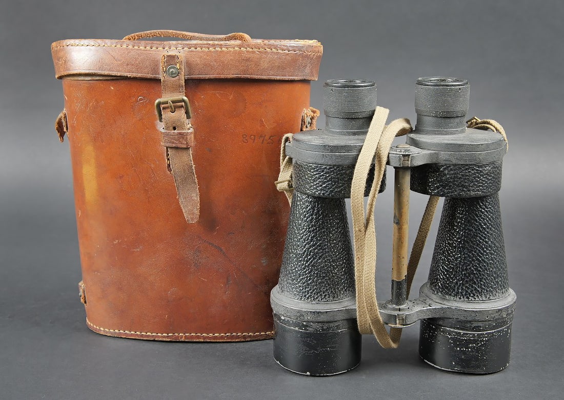 Jumelles Britannique. British Binoculars.: Jumelles britannique. Housse en epais cuir marron. La poignee de transport est presente. La sangle de transport est manquante. Un passant lateral est casse. Marquages sur le couvercle Binocular