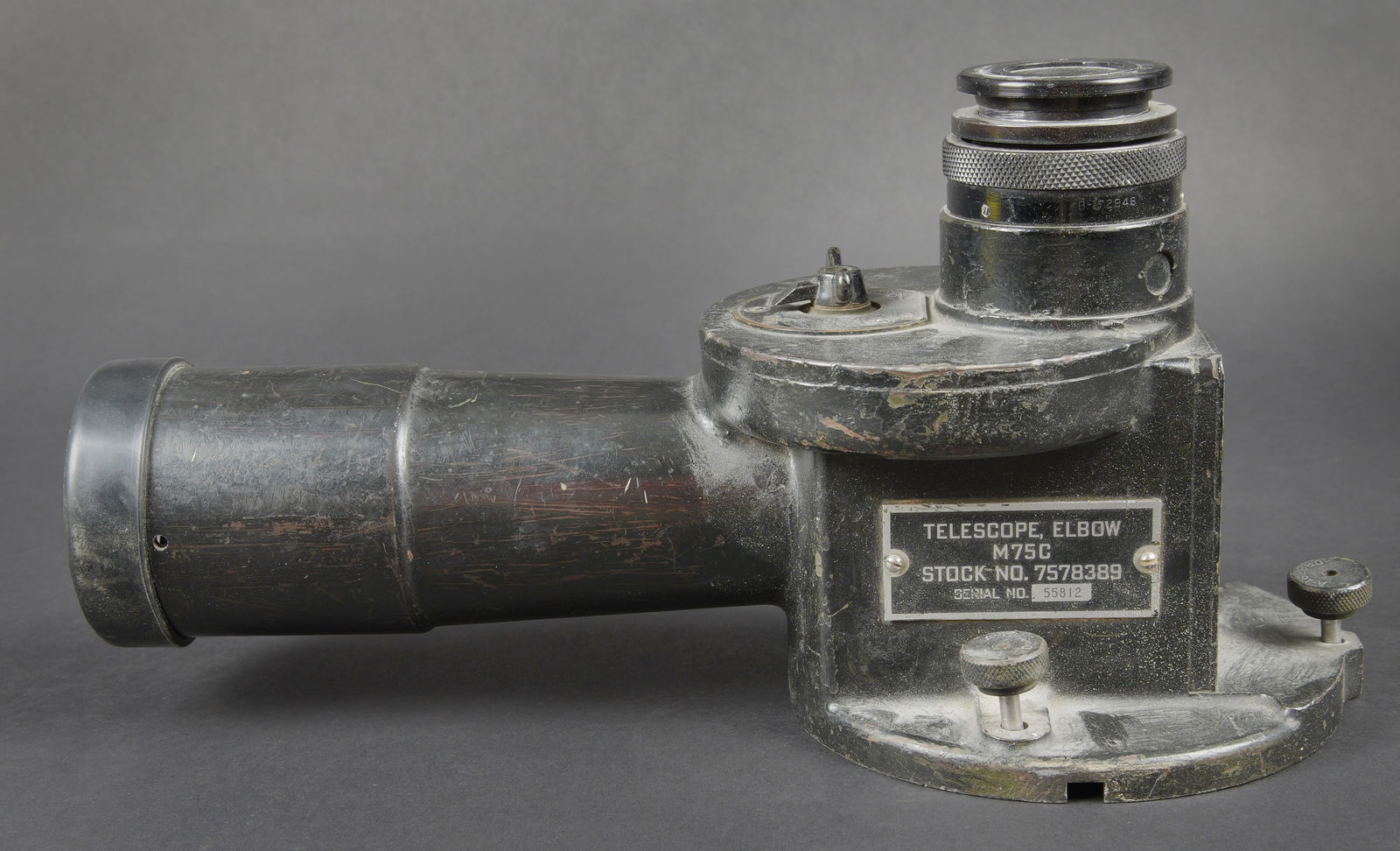 Telescope Elbow. Elbow telescope: Telescope Elbow. En metal, peinture noire a 60%. Plaquette marquee Telescope Elbow M75C. Stock No 7578389 Nr 55812. Les vis de fixation au trepied sont presentes. Optique claire et graduee presentant