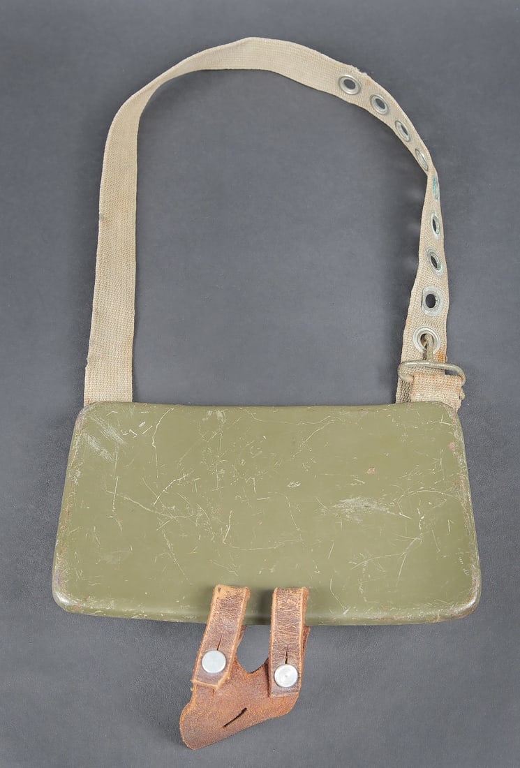 Plaque de poitrine pour telemetre WH.: Plaque de poitrine pour telemetre WH. Plaque en metal, disposant de trois points de fixation pour les pieds du petit telemetre WH. Patte de boutonniere en cuir marron, visiblement posterieure. Sangle