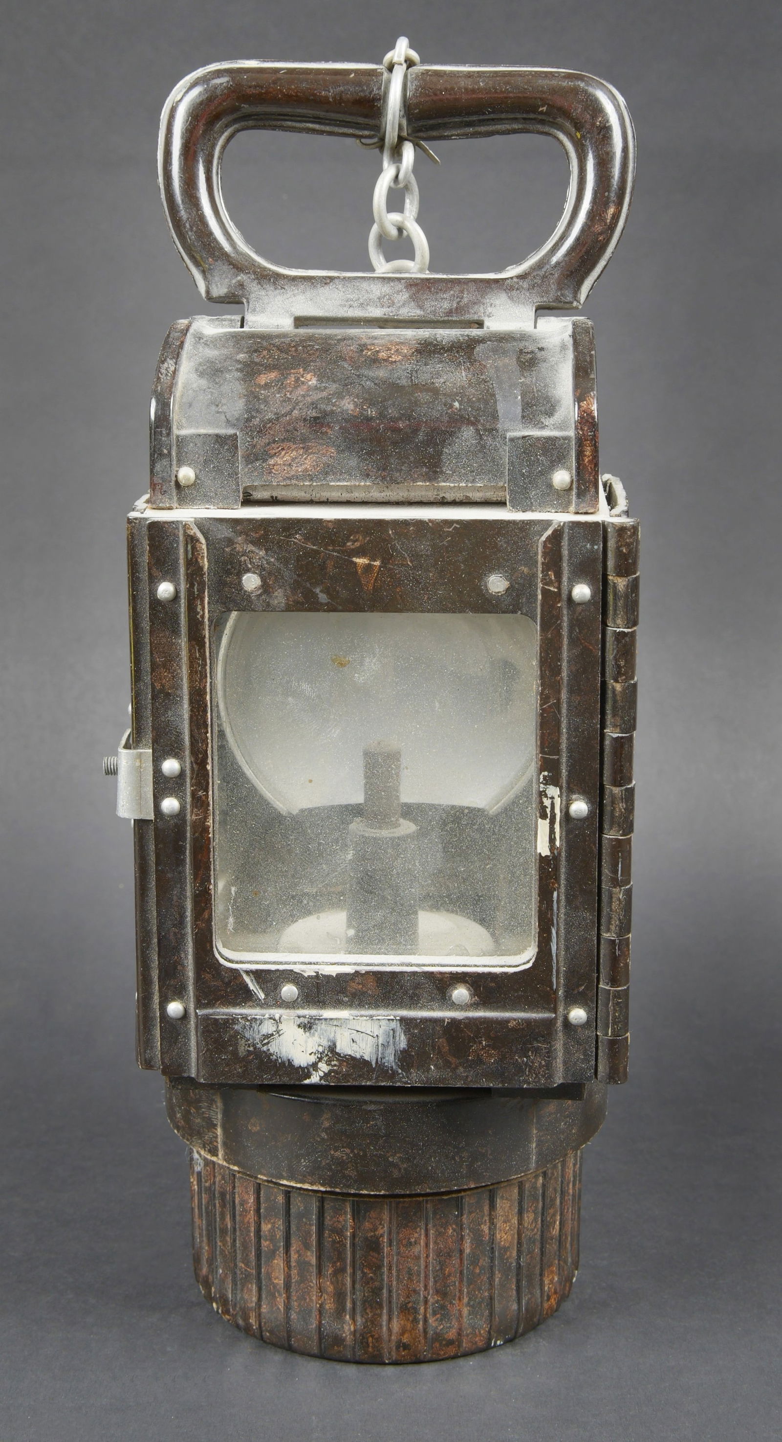 Lampe en bakelite WH. WH bakelite lamp: Lampe en bakelite WH. En bakelite marron fonce. Le crochet de fixation au plafond est manquant. Chainette presente. Une vitre manquante. Filtre a carbure complet. Tous les accessoires sont absents. Be