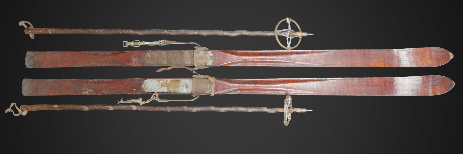 Ski allemand. German skis: Ski allemand. En bois. Paire homogene. Fixation en metal, les sangles sont presentes. Marquages Waa visibles. Une paire de batons en bois. Les sangles sont presentes. Longueur des skis environ 2 metre