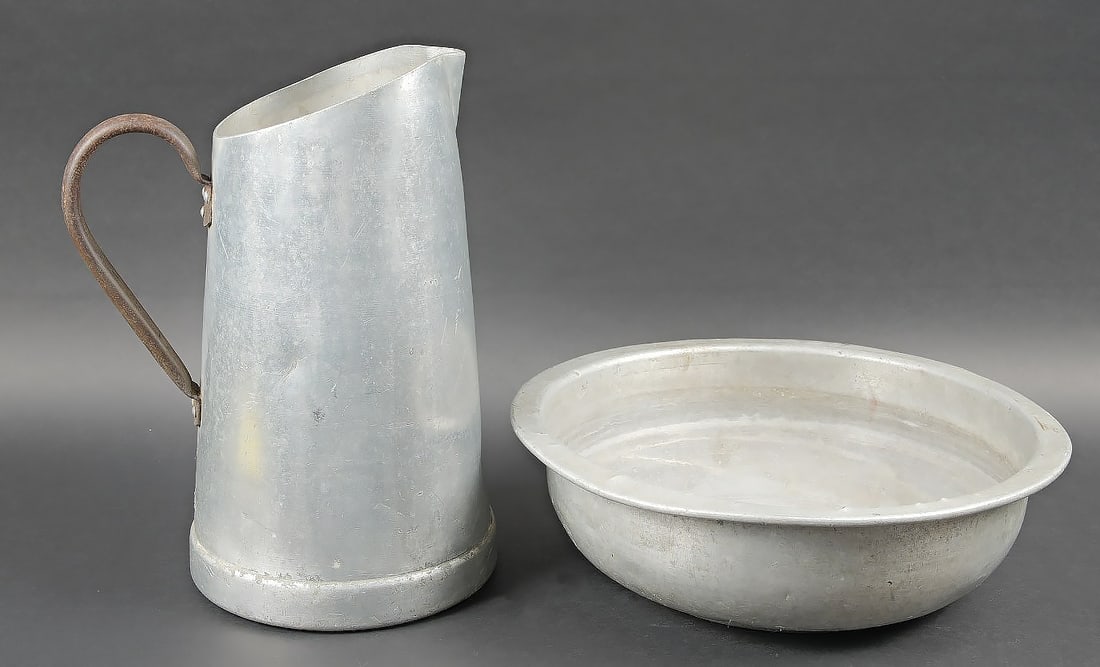 Plat et broc de la LW. LW plate and pitcher: Plat et broc de la Luftwaffe. Broc en metal et poignee oxydee, hauteur 38, cm. Beau marquages de la Luftwaffe FLUV, date illisible. Un plat de toilette en aluminium, fortement bossele, beau marquages