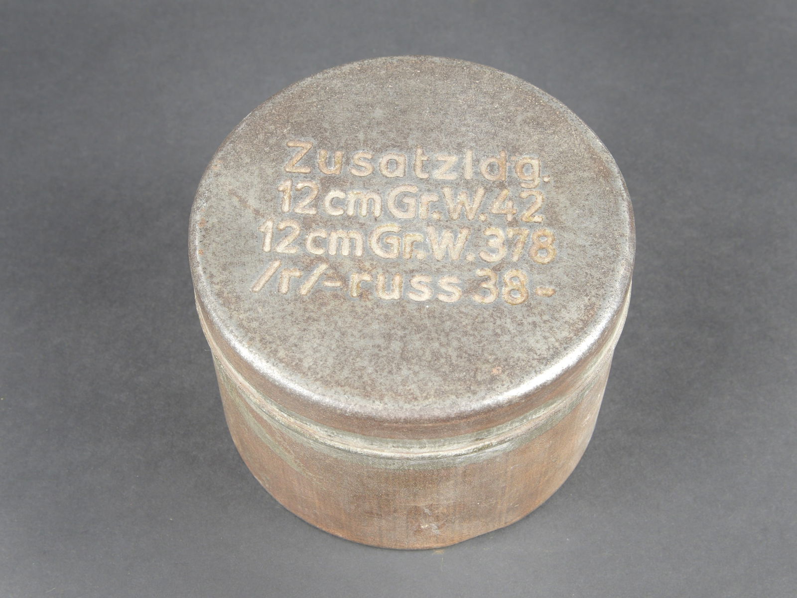 Boite pour gargousse de poudre WH. Propellant charge case for Wehrmacht artillery.: Boite pour gargousse de poudre WH. En metal. Vide. Completement depourvue de peinture. Couvercle marquee Zusatzldg 12 cm Gr W42 12 cm Gr W 378 r Russ 38. Fabrication MKL 1943. A noter une certaine
