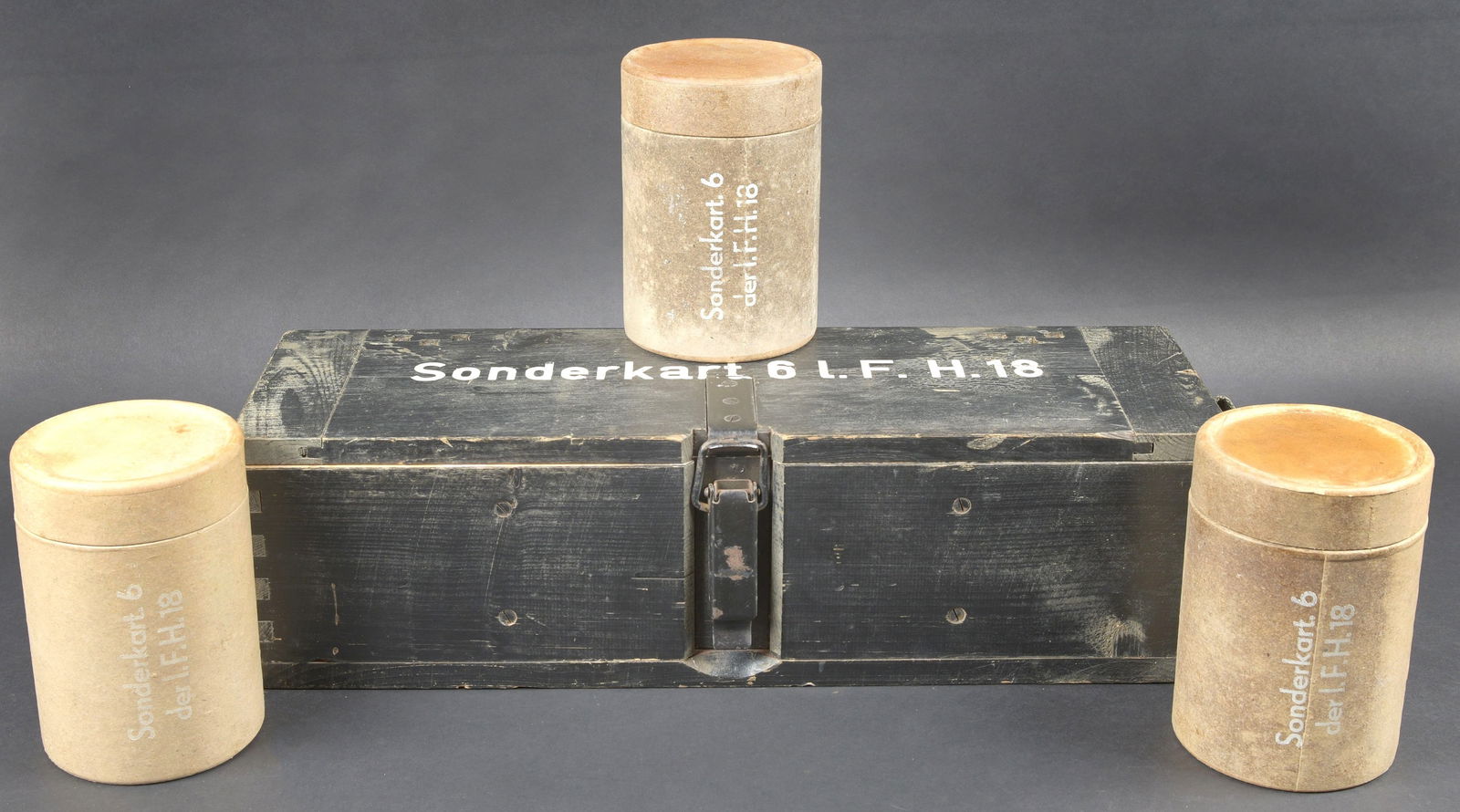 Caisse 6 LF H 18. Crate for six rounds for 10.5 cm le.F.H.18.: Caisse 6 L F H 18. Belle caisse en bois. Peinture noire a 70%. Le crochet de fermeture est complet. Sangle de transport en toile. Couvercle marque Sonderkart 6 L F H 18. Contenant trois container en c