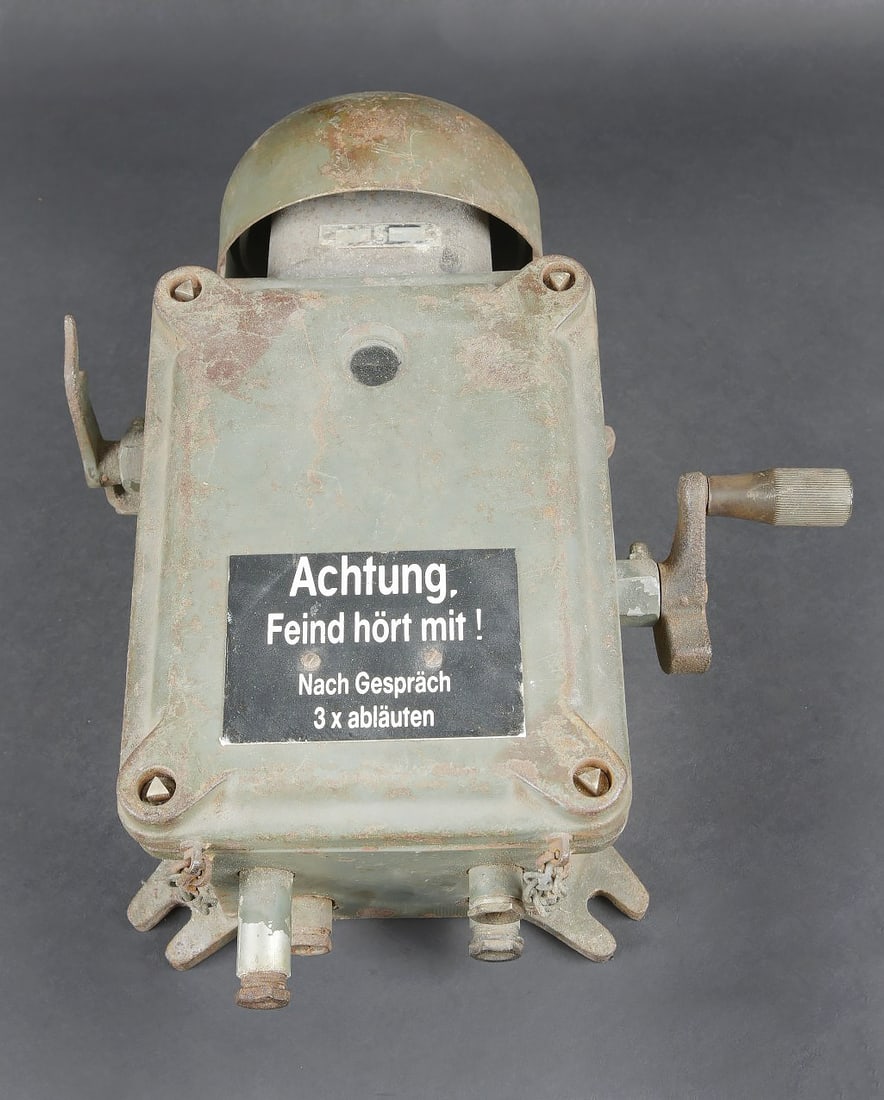 Telephone de bunker WH. WH bunker telephone: Telephone de bunker WH. Grand modele en metal. Le combine est manquant ainsi que tous les cables. Les attaches murales sont presentes. Cloche complete, mais presentant quelques bosses. Peinture Feldgr