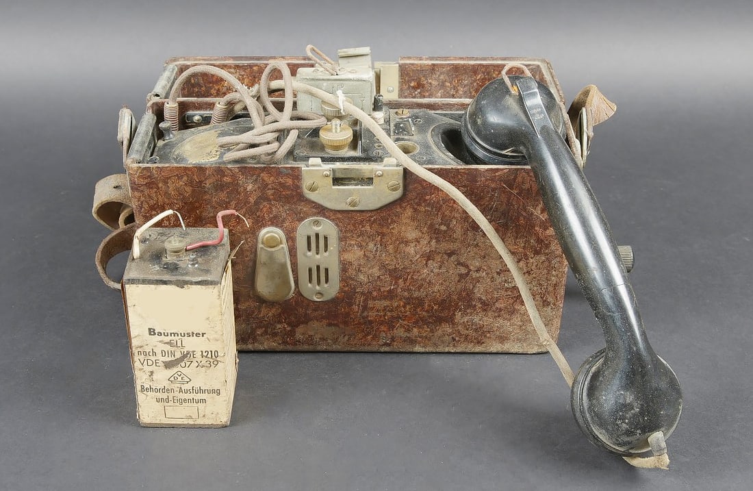 Telephone de campagne WH. WH field telephone: Telephone de campagne WH. En bakelite marron. La manivelle est presente. Sangle de transport en marron. Celle-ci presente des craquelures et des traces d oxydation. Fabrication de 1939, numero 08478.