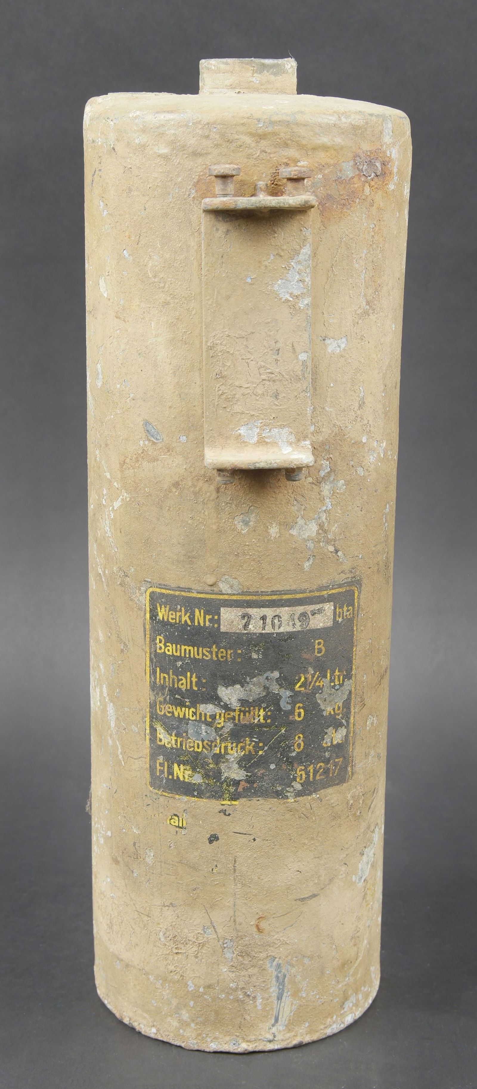 Extincteur de vehicule WH. WH vehicle fire extinguisher: Extincteur de vehicule WH. En metal. Incomplet. Peinture jaune sable a 70%. Etiquette marquee Werk Nr 21049 BTA, Baumuster B, Inhalt 2 1/4 ltr, Gewicht gefult 6kg, FL NR 61217. Vide. A noter une certa