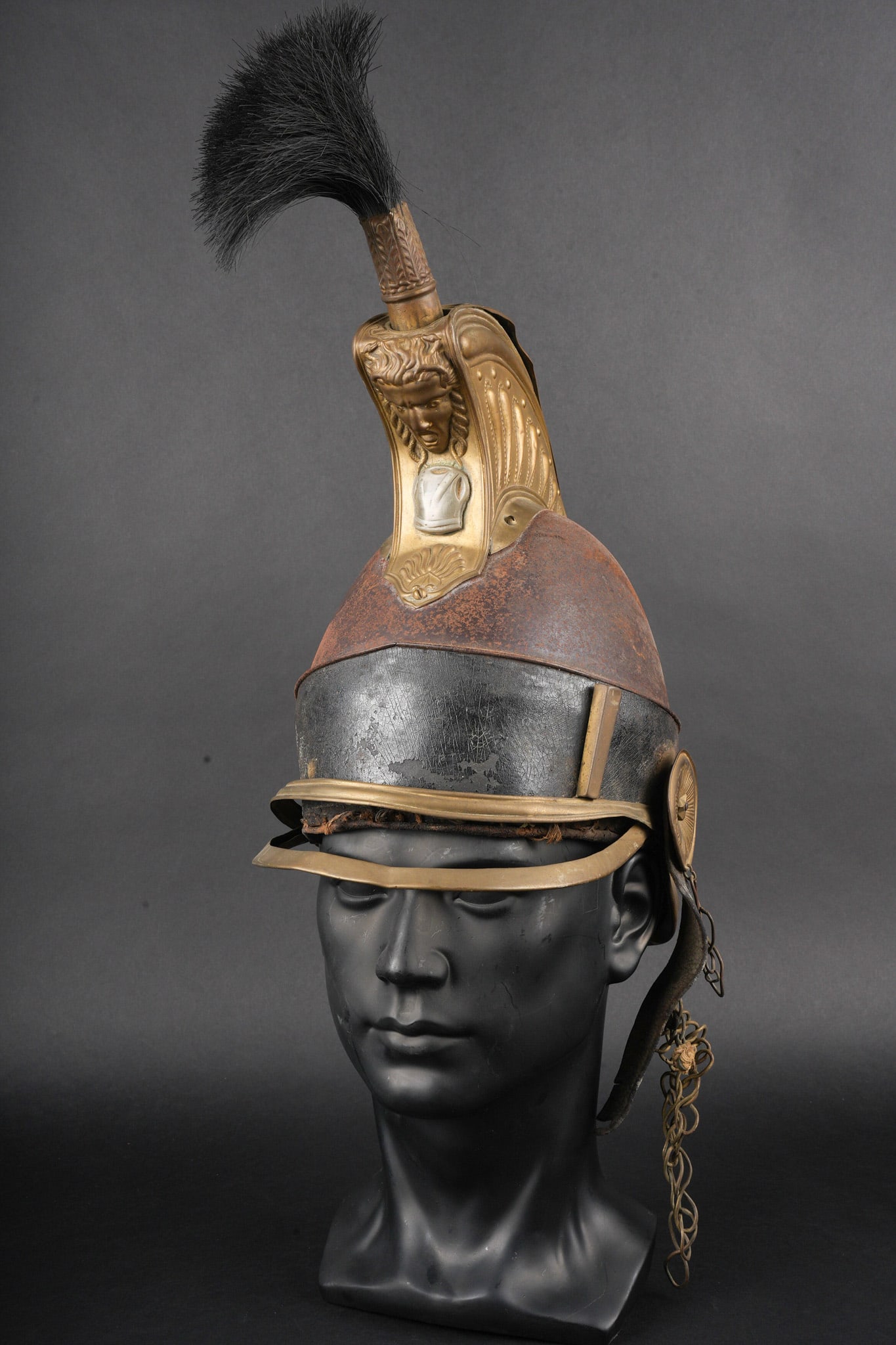 Casque de cuirassier belge 1830. Belgian cuirassier helmet, model 1830: Casque de cuirassier belge 1830. Bombe en tole d acier, cimier en laiton portant une cuirasse en metal blanc sous le masque. Bandeau en cuir faisant le tour de la coiffure, nuquiere en cuir, visiere e