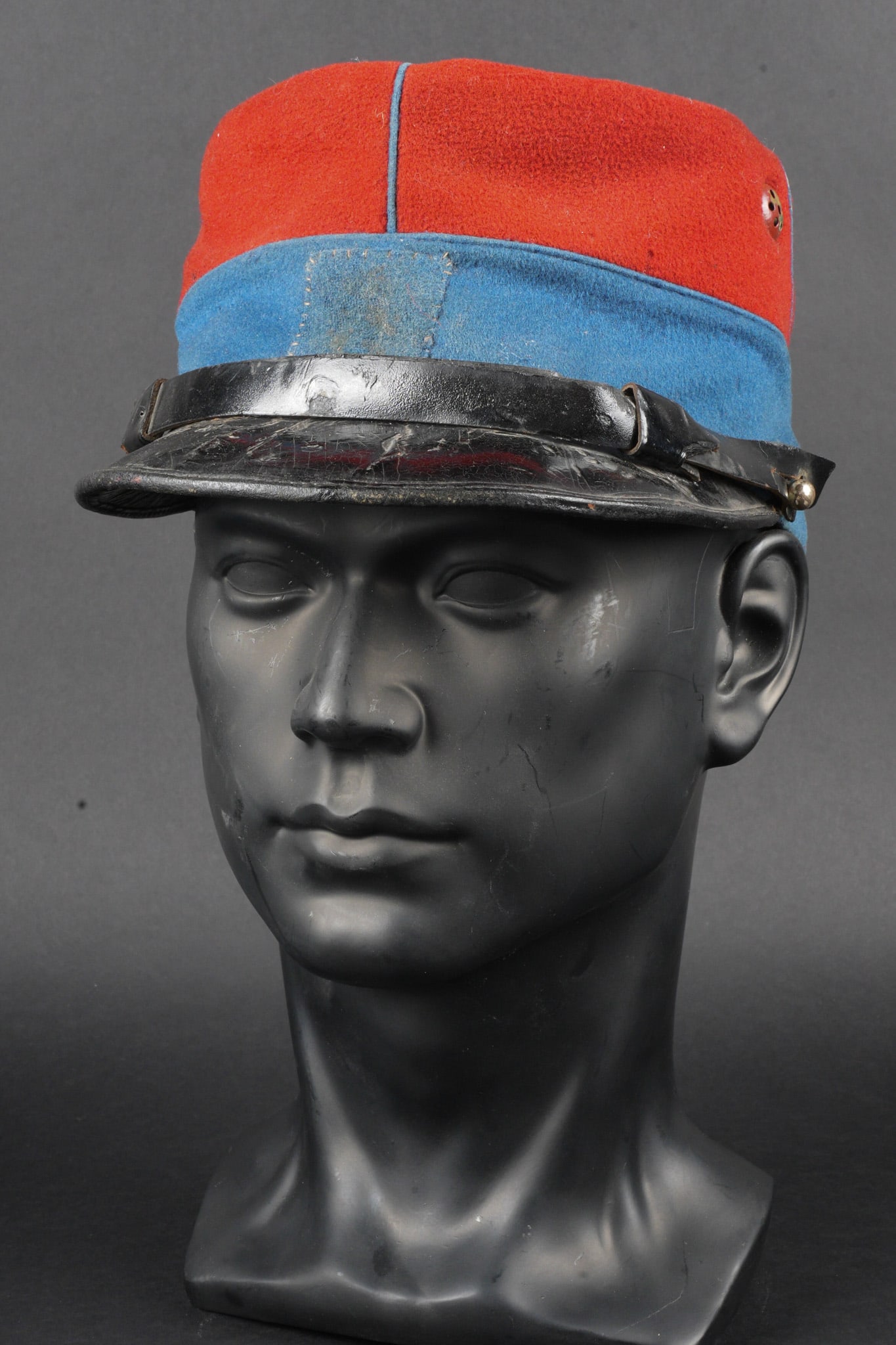 Kepi 1884 cavalerie legere. Model 1884 light cavalry kepi.: Kepi 1884 cavalerie legere. Kepi modele 1884, confectionne en drap garance, bandeau en drap bleu ciel, passepoil en drap bleu ciel. Carre en drap bleu ciel rapporte a l avant sur lequel se trouvait le