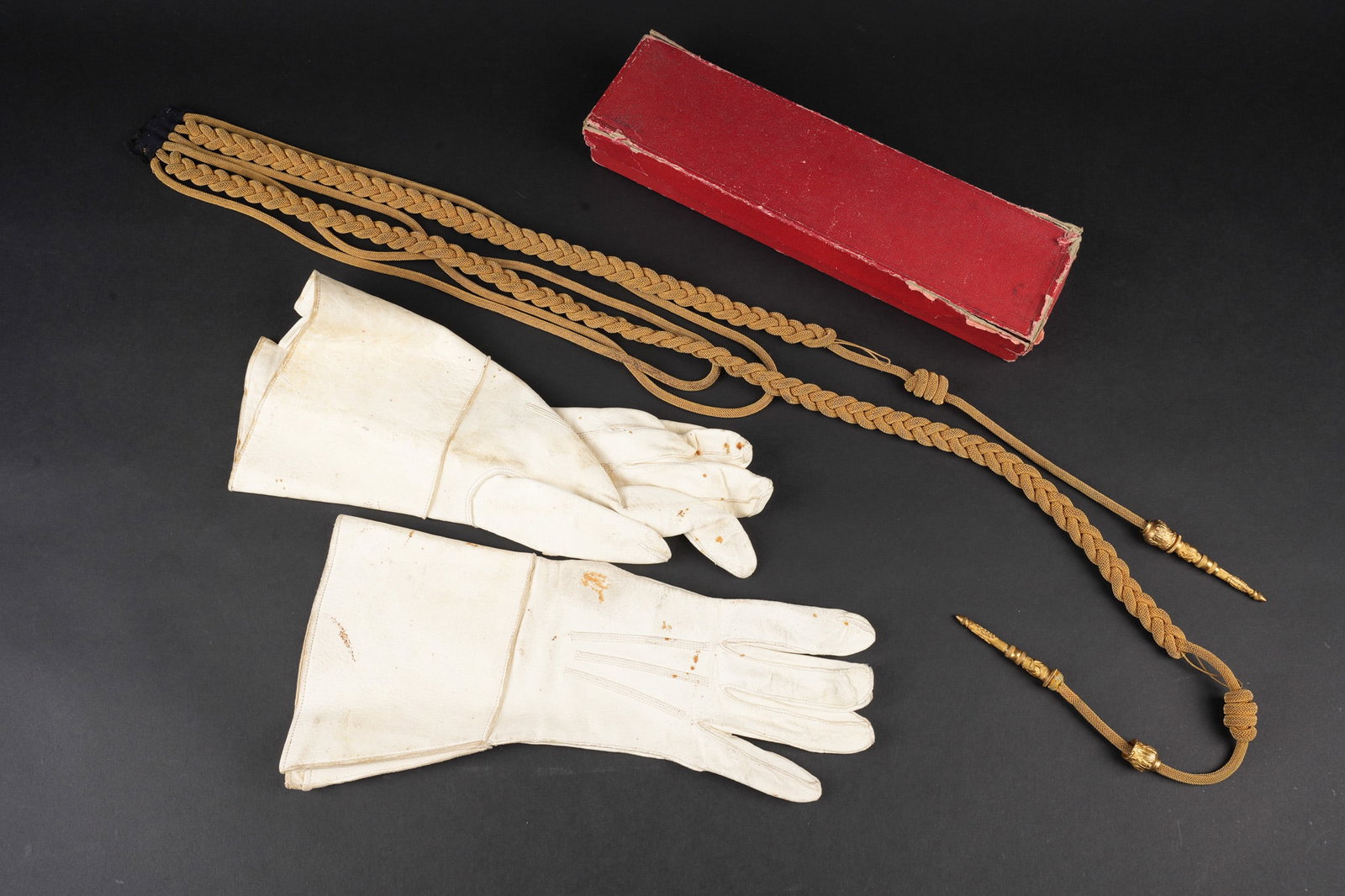Ensemble d officier Garde Republicaine. Republican Guard officer’s grouping.: Ensemble d officier Garde Republicaine. Comprenant une paire de gants d officier en crispin blanc, taille 8. Une fourragere d officier superieur dans sa boite d origine, en cannetille doree avec sa pa