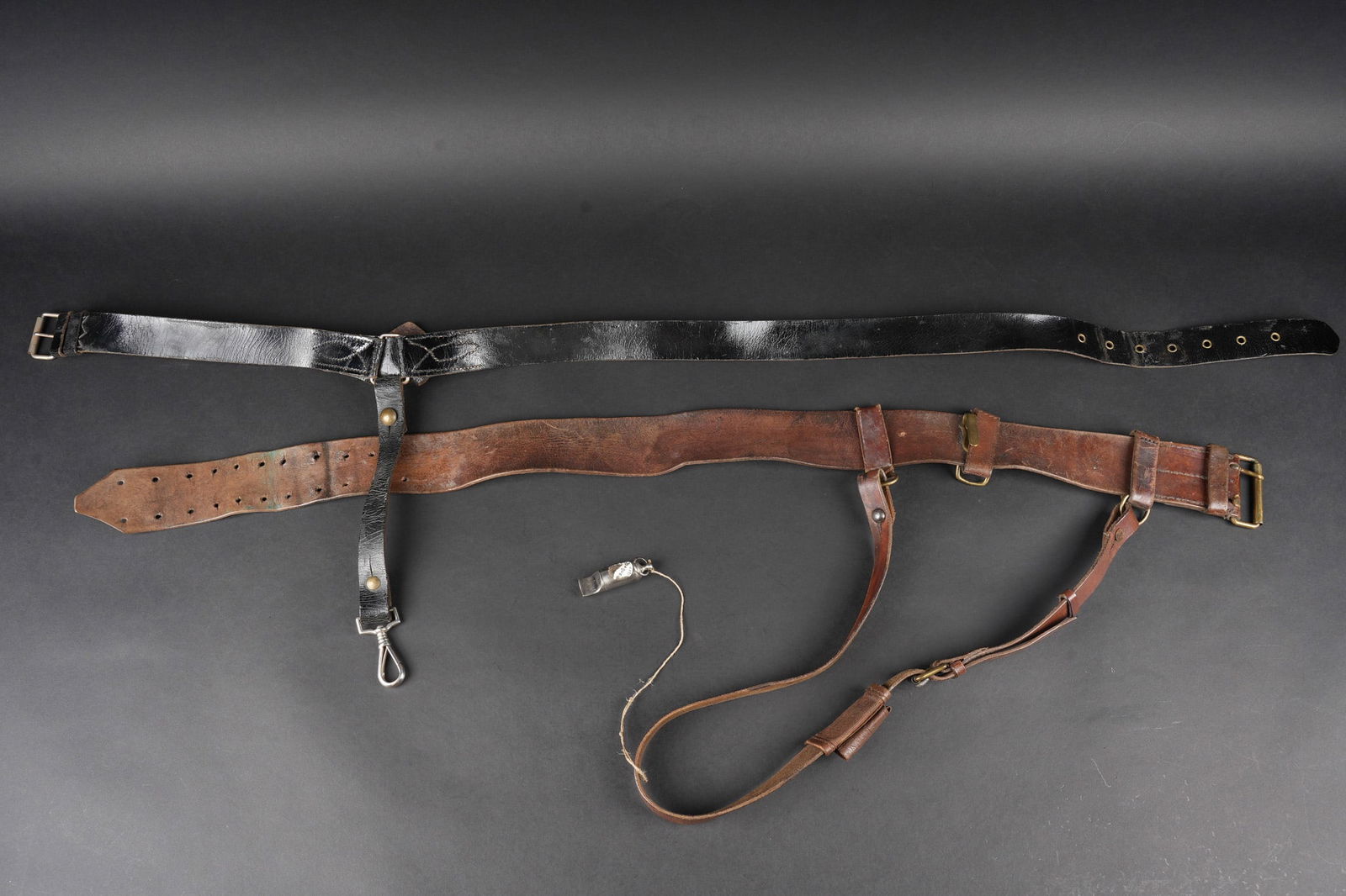 Ensemble de ceinturons. Set of belts.: Ensemble de ceinturons. Comprenant un ceinturon d officier IIIeme Republique en cuir verni avec sa beliere porte sabre. Un ceinturon d officier en cuir fauve confectionne a partir d un ceinturon troup
