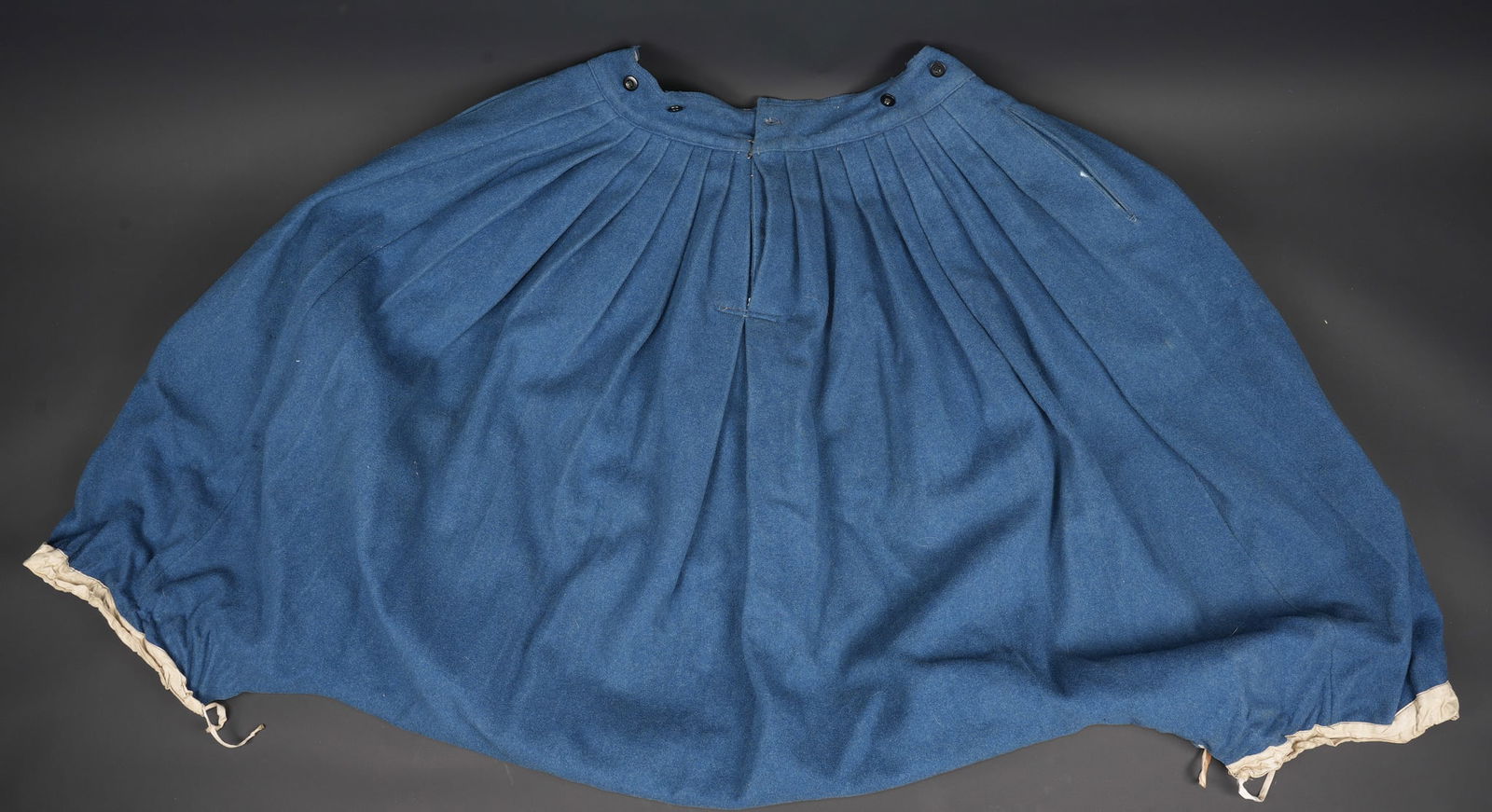 Pantalon oriental de spahis. Spahi oriental trousers.: Pantalon oriental de spahis. Confectionne en drap bleu de ciel et de forme tres ample, doublure en coton ecru possedant un tampon de taille ainsi qu un tampon de reception illisible et celui d un cost