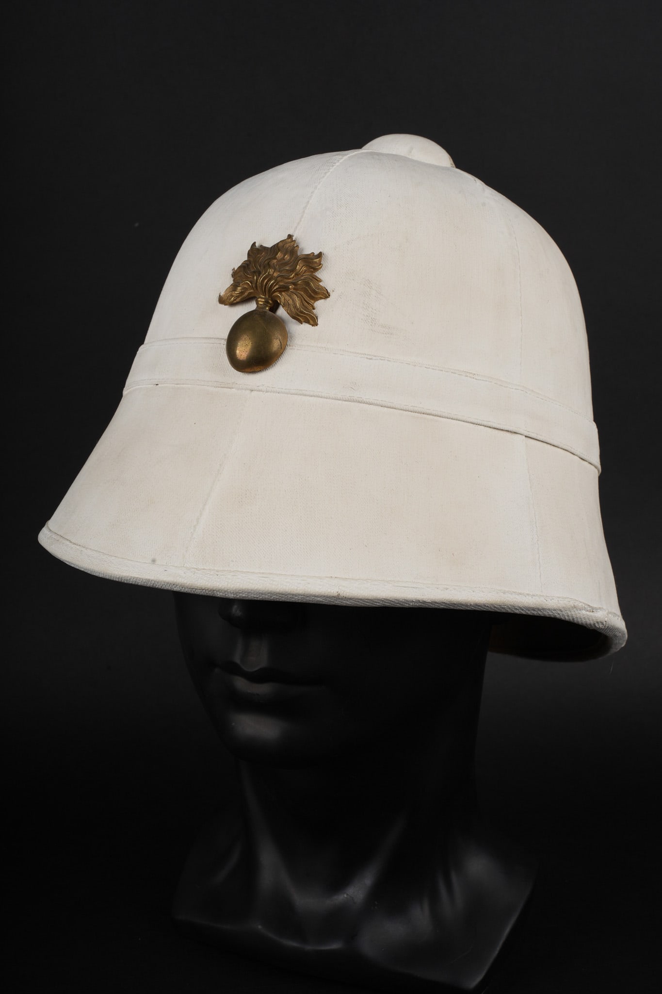 Casque colonial pain de sucre. Colonial pain de sucre helmet.: Casque colonial pain de sucre. En liege recouvert d une toile kaki claire entierement recouverte a la chaux blanche. Doublure en fin tissu vert, coiffe en cuir abimee, un crochet de jugulaire absent,