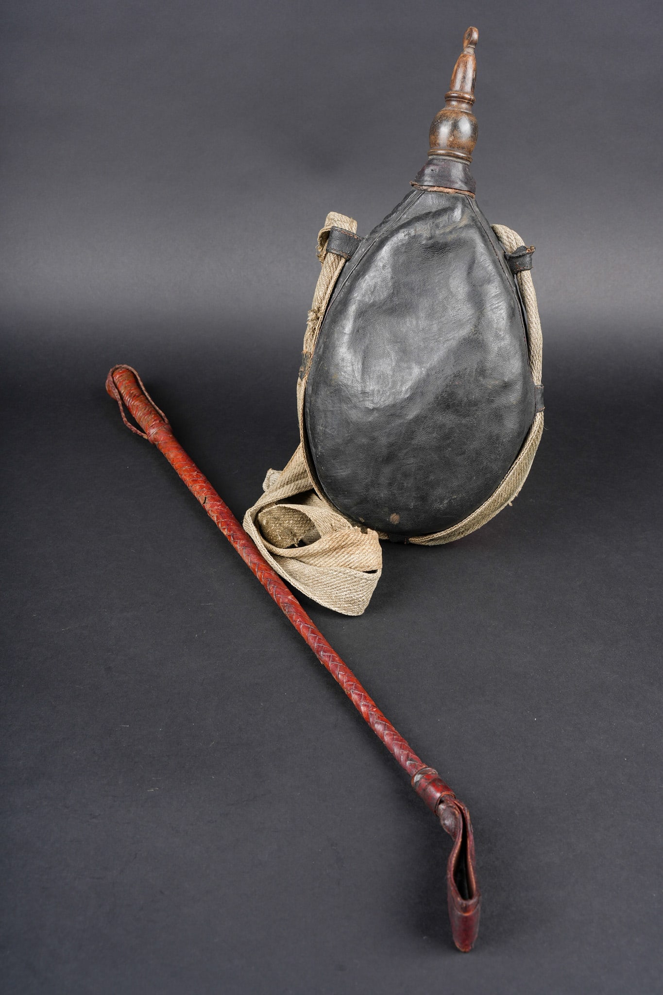 Ensemble troupes d Afrique. Army of Africa grouping.: Ensemble troupes d Afrique. Comprenant une gourde souple en peau typique des troupes d Afrique, sangle de portage provenant d une musette 1892. Un stick d officier en cuir brun, sur le pommeau se trou