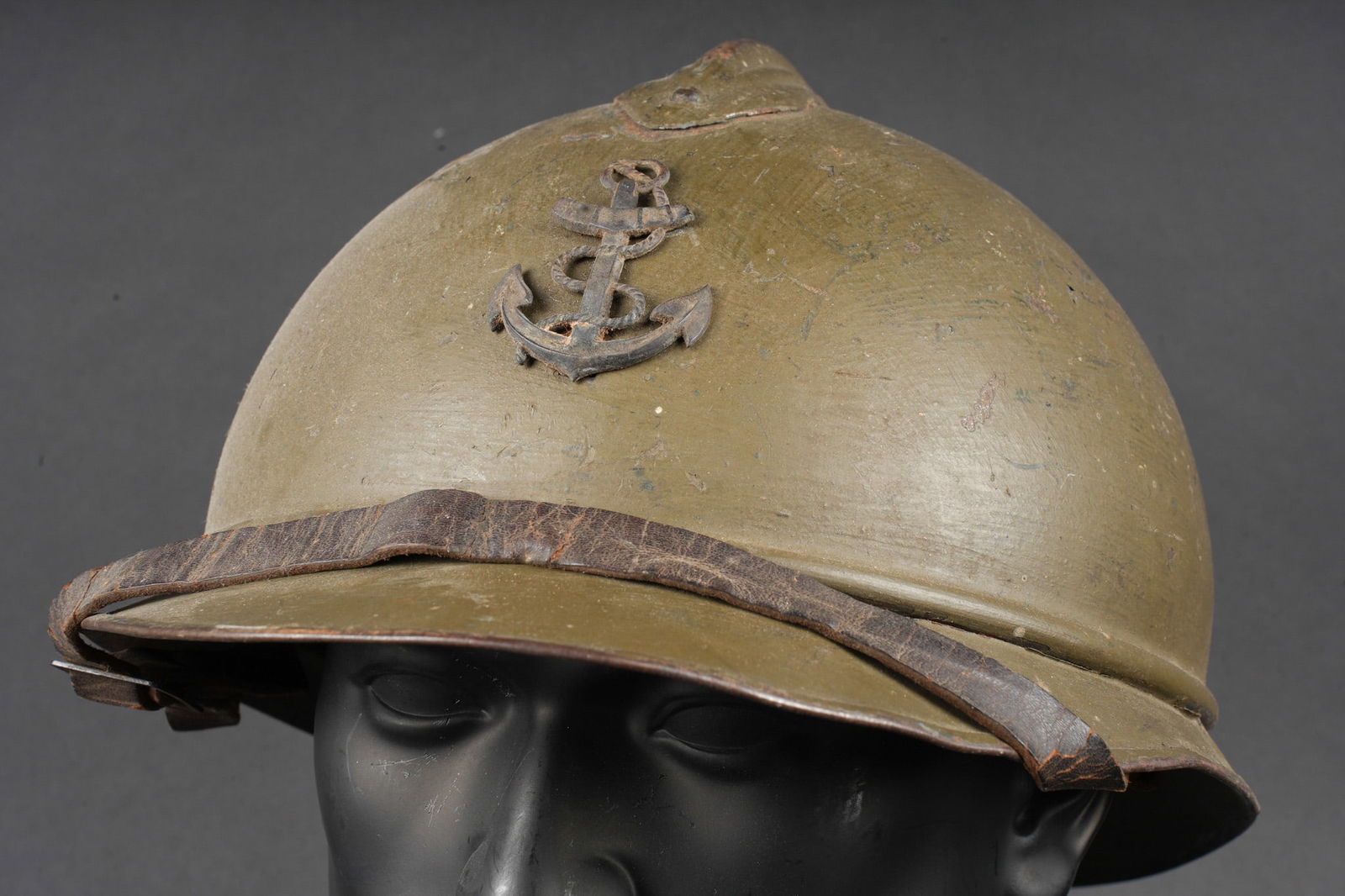 Casque Adrian infanterie coloniale. Adrian helmet, Colonial Infantry.: Casque Adrian infanterie coloniale. Casque modele 1915 en bleu horizon d usine recouvert d une peinture kaki au pinceau. Insigne frontal a l ancre coloniale en metal rapporte de type officier. Coiffe