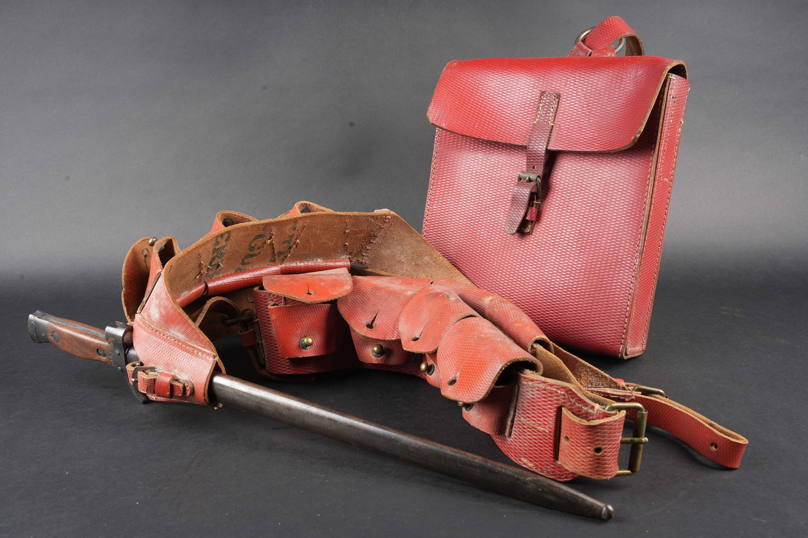 Ensemble d equipements spahis. Spahi equipment grouping.: Ensemble d equipements spahis. Comprenant un ceinturon porte cartouches de spahis, baudrier modele 1935 confectionne en cuir rouge gaufre a cinq compartiments pour lames chargeurs et porte baionnette