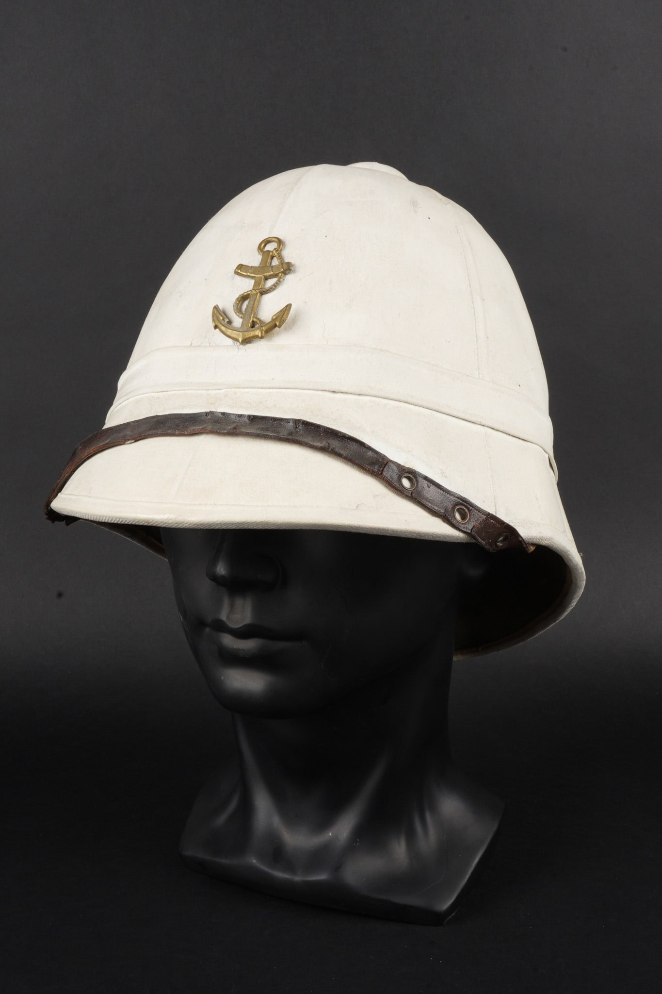 Casque colonial pain de sucre. Colonial pain de sucre helmet.: Casque colonial pain de sucre. En liege recouvert d une toile kaki claire entierement recouverte a la chaux blanche. Doublure en fin tissu vert, coiffe en cuir abimee, deux crochets retiennent une