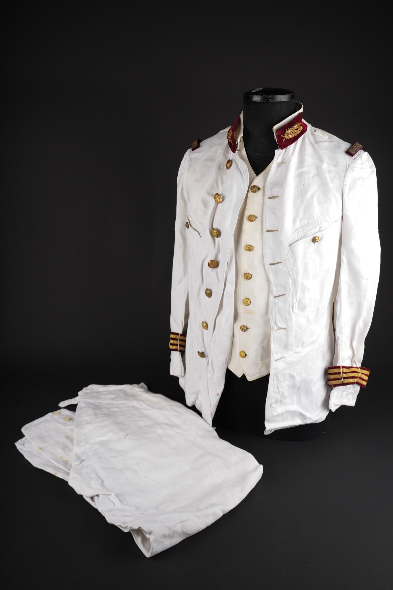 Ensemble de medecin colonial. Colonial medical service grouping.: Ensemble de medecin colonial. Comprenant sa veste en fine toile de coton blanc se fermant a l aide de sept boutons aux armes de l infanterie coloniale. Pattes de col de type officier du service de