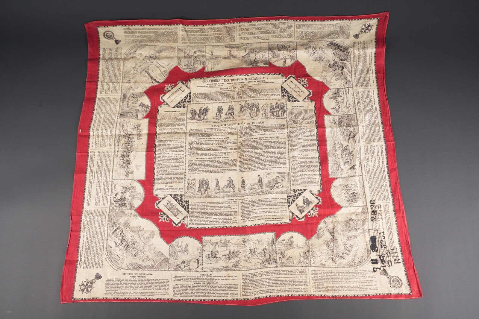 Mouchoir d instruction militaire N7. Military instruction handkerchief No. 7: Mouchoir d instruction militaire N7. Mouchoir sur le theme de l hygiene en campagne et presentant les manœuvres a effectuer pour le transport des blesses, divers representation. Le mouchoir porte