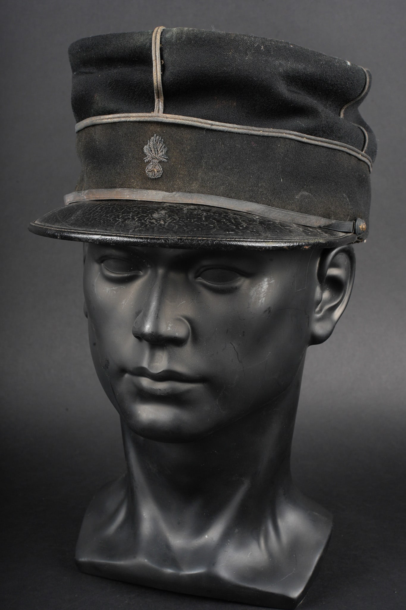 Kepi 1873 de sous lieutenant du genie. Kepi, Model 1873, engineer second lieutenant: Kepi de sous lieutenant du genie. En fin drap noir, grenade d etat major brodee cannetille, galons dores cousus d origine. Fine jugulaire doree retenue par deux boutons du genie. Visiere en cuir