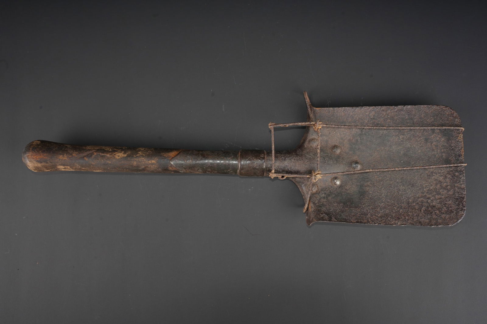 Pelle et porte pelle ersatz. Entrenching shovel with ersatz carrier: Pelle et porte pelle ersatz. Pelle beche droite avec son manche d origine , partie metallique oxydee. Porte pelle ersatz realise en fil de fer. Entrenching tool and ersatz carrier. Straight spade with