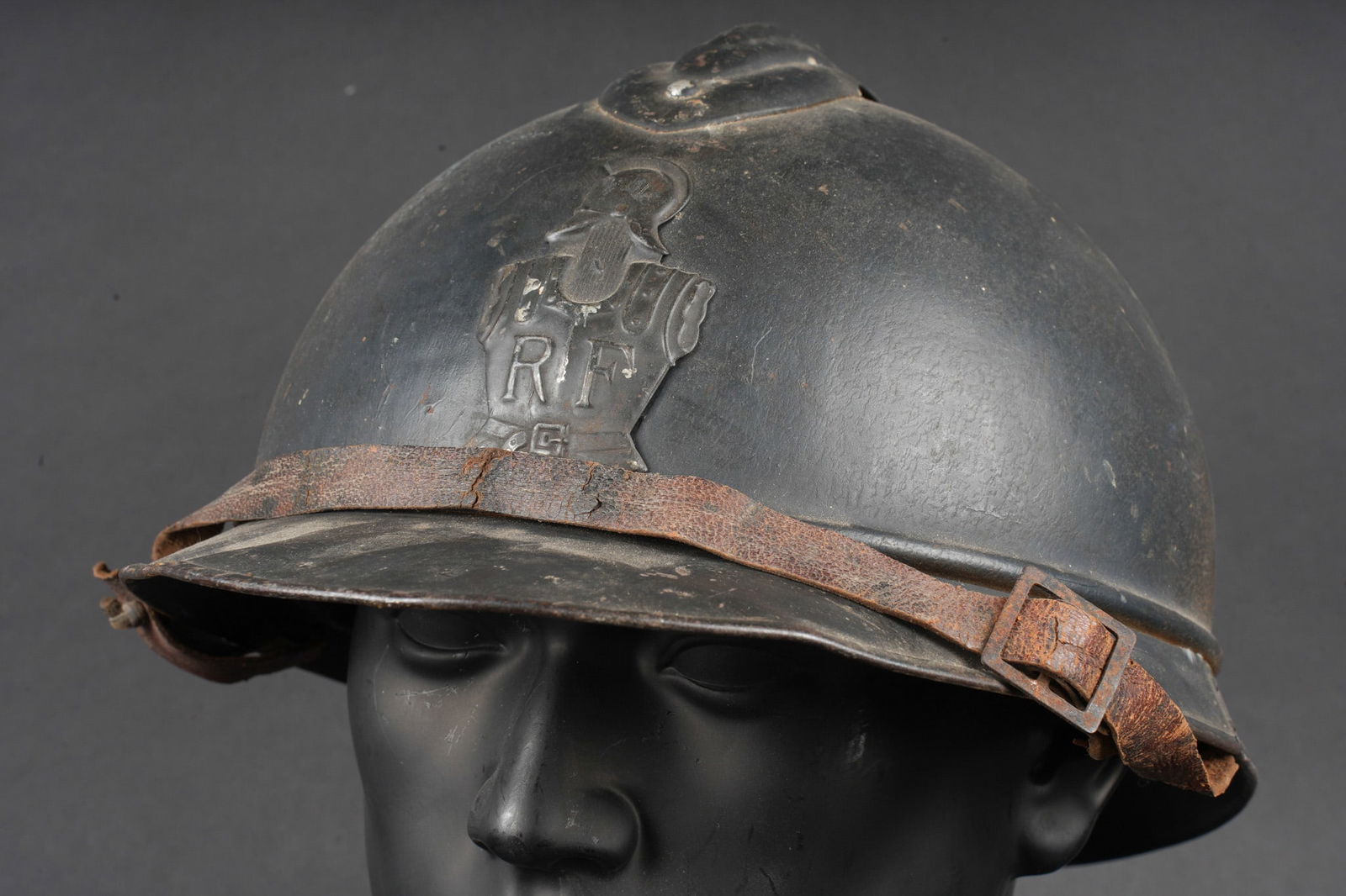 Casque Adrian 1915 Genie. Adrian helmet, Model 1915, Engineers: Casque Adrian 1915 genie. Casque modele 1915 dans sa peinture d usine bleu fonce, attribut du genie modele 1915. Jugulaire en cuir fauve dont le rivet de fixation a cede, coiffe du second type en