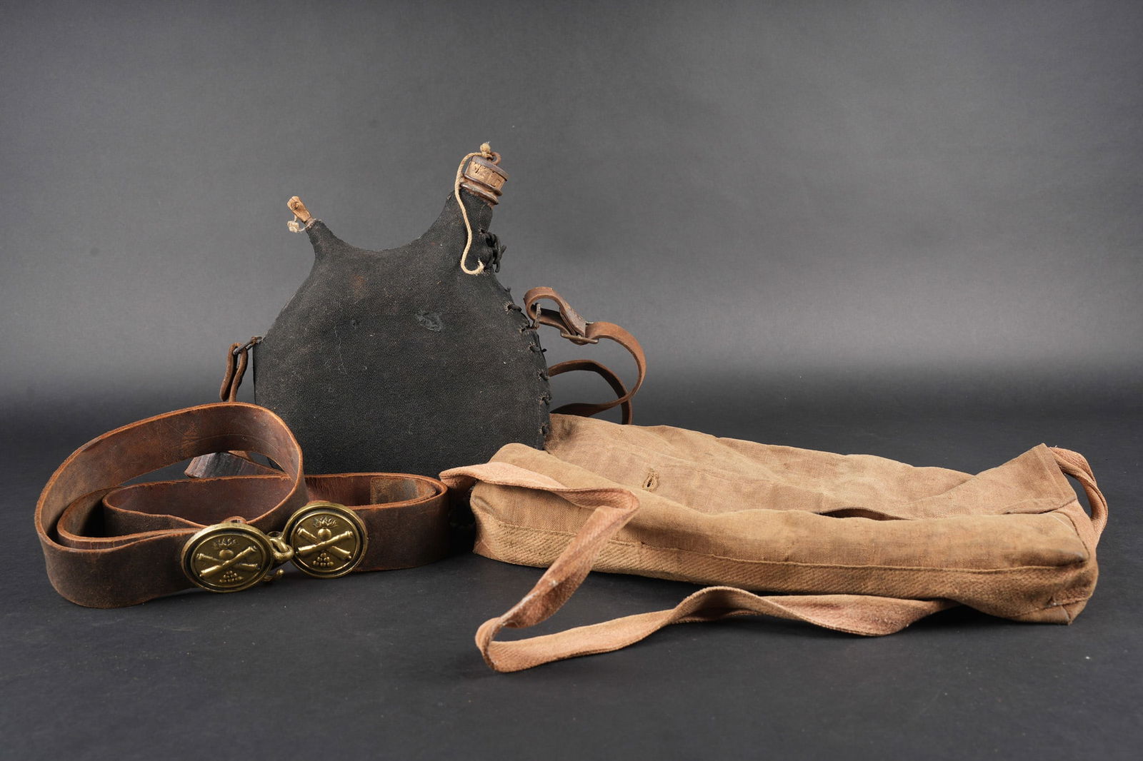 Ensemble d equipements. Equipment set: Ensemble d equipements. Comprenant un bidon 1877 avec sa housse en drap gris de fer bleute, bouchon present, etiquette en coton indiquant l unite du 337me de ligne, courroie de transport presente. Une